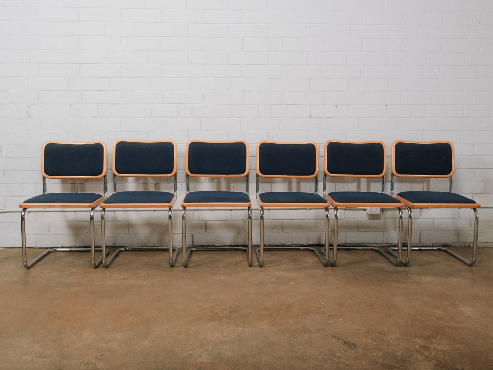 Set of 6 Mid-Century Modern Cantilever Dining Chairs: Set of six mid-century modern cantilever dining chairs featuring bent chrome tubular frames, light wood trim, and navy blue upholstered seats and backs. The clean-lined armless design offers a classic