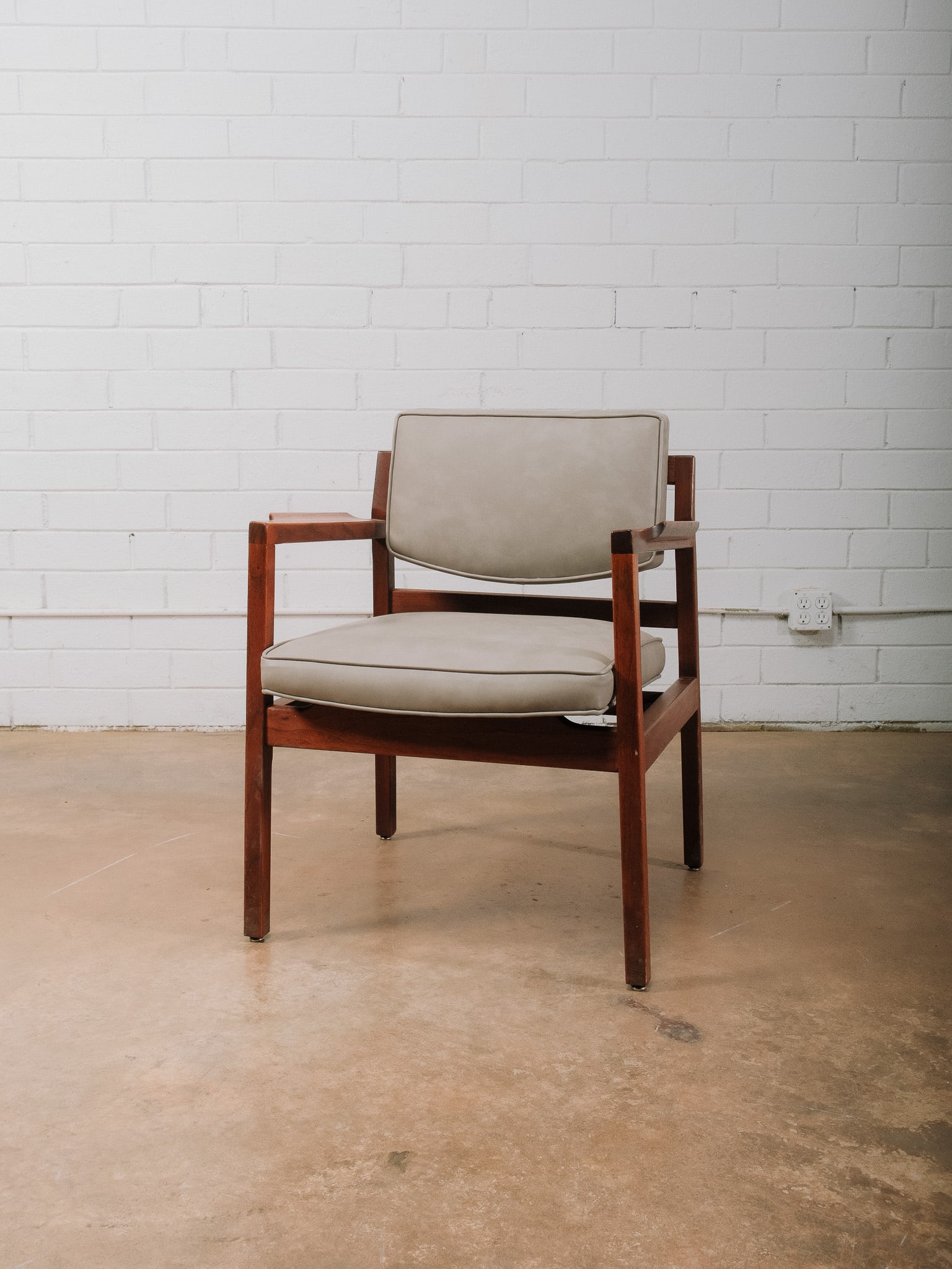 Grey MCM Accent Chair: Mid-century modern accent chair featuring a solid wood frame with clean architectural lines and upholstered leather seat and back cushions. The open-arm design offers comfortable seating while