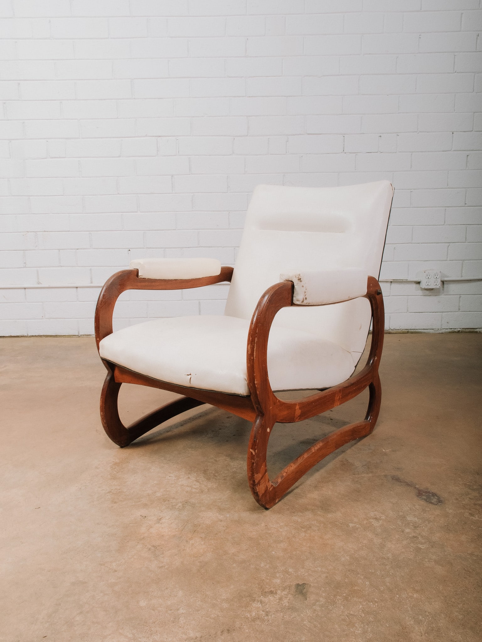 White MCM Bentwood Accent Chair: Mid-century modern accent chair featuring a striking sculptural bentwood frame with sweeping curved arms and sled-style supports. Upholstered in white vegan leather with brass nailhead accents on back