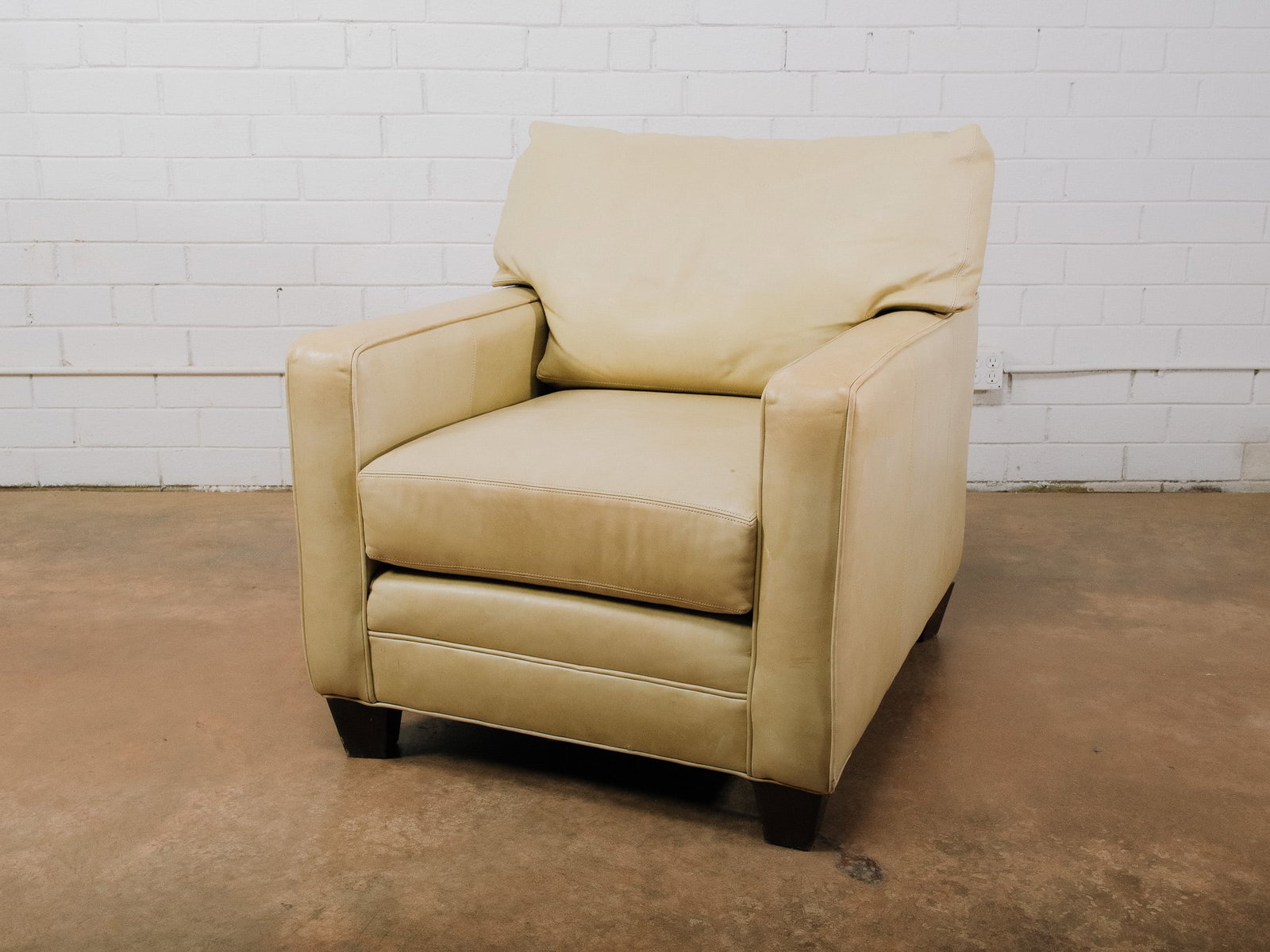 Light Green Leather Armchair: Contemporary armchair upholstered in light green leather with clean, tailored lines and generously padded cushions for exceptional comfort. Features squared track arms, a deep seat, and dark wood