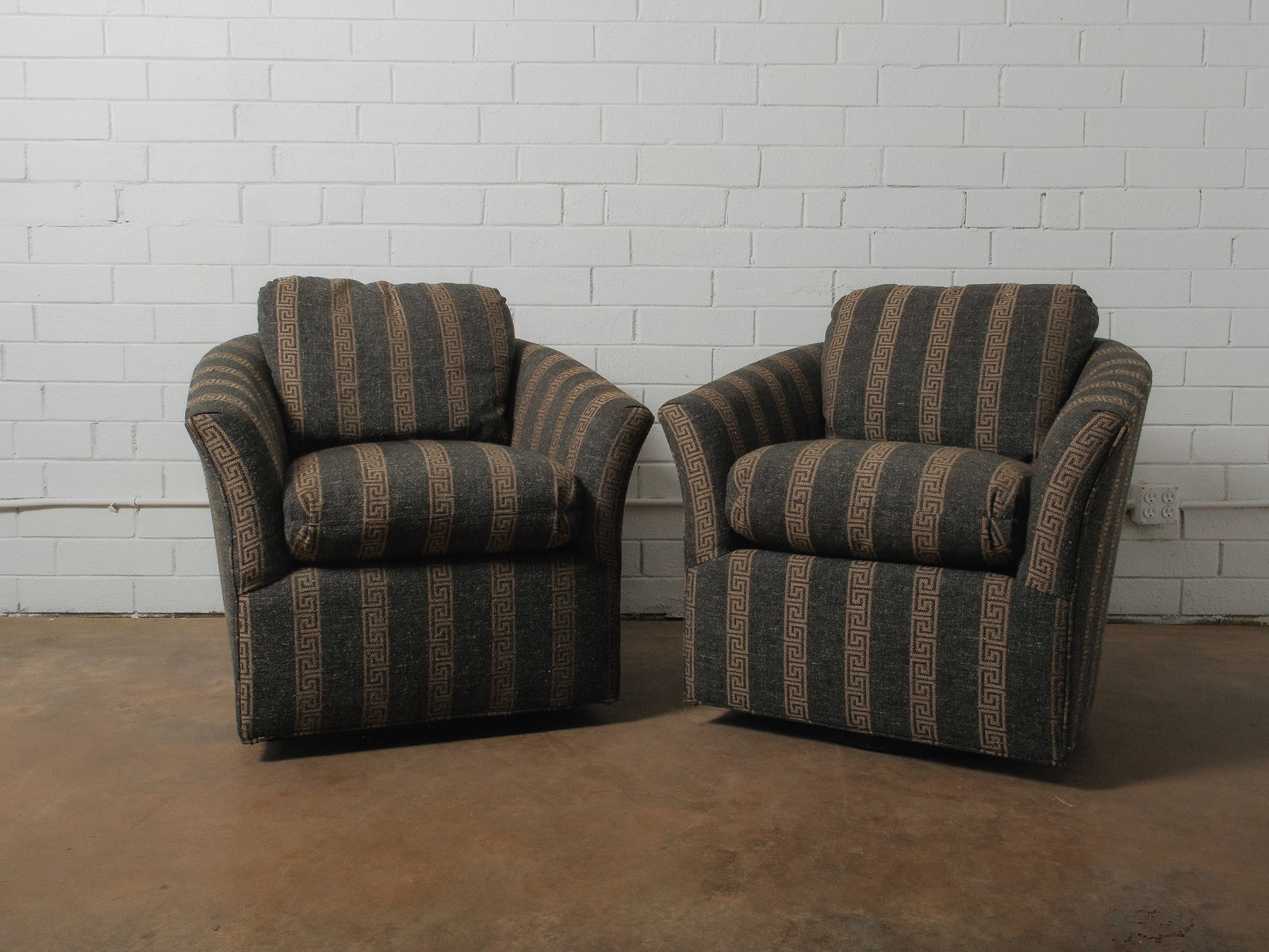 Pair of Vintage Club Chairs: Cozy pair of vintage club chairs with curved arms and patterned upholstery. Comfortable lounge seating with a classic silhouette.Seat Height: 12"Seat Depth: 19"