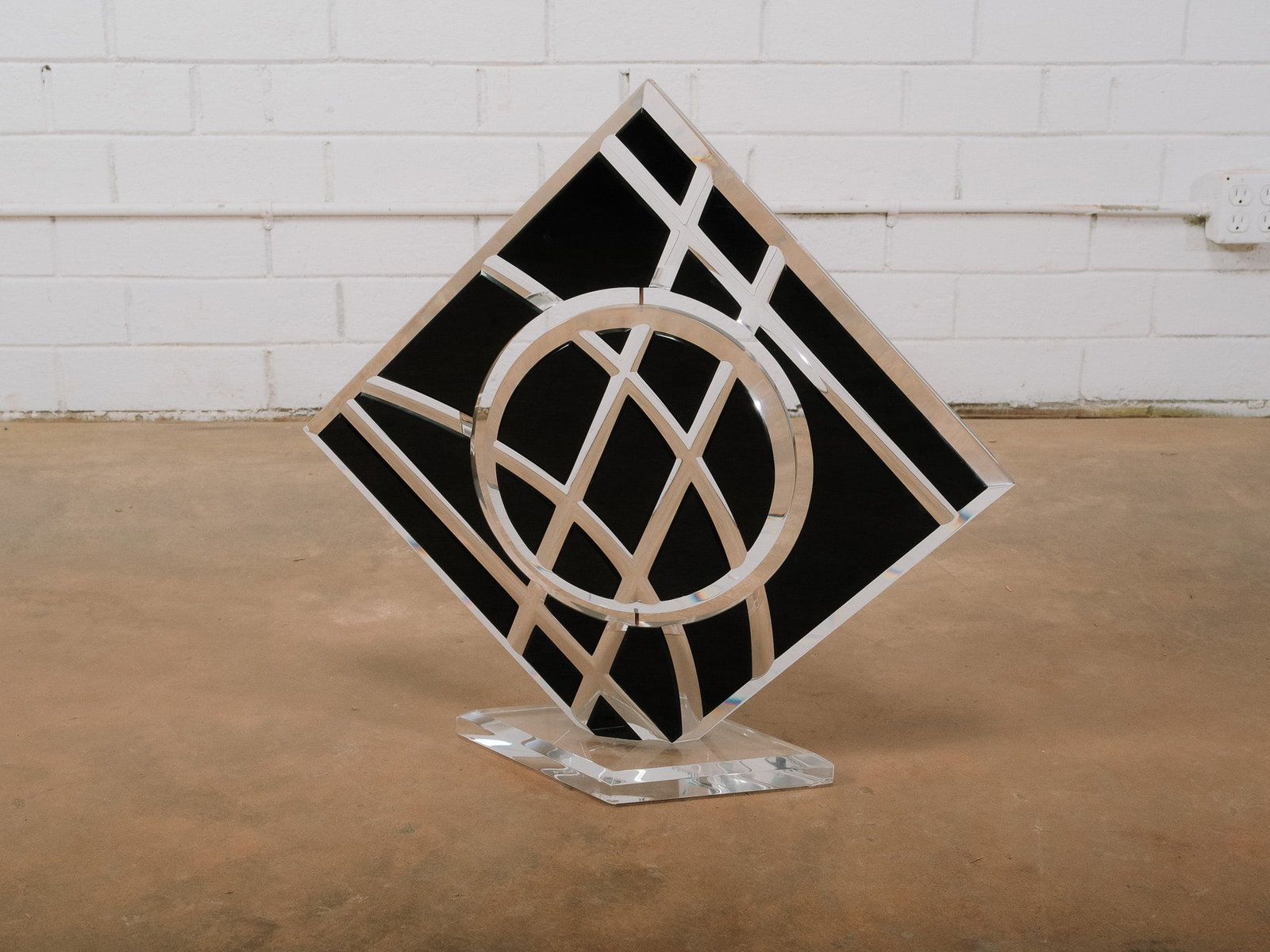 Art Deco Style Geometric Glass Sculpture: Art Deco-inspired geometric glass sculpture featuring mirrored and black glass panels with polished metal accents in a striking circular and linear composition. Mounted on a chrome-finished base, this