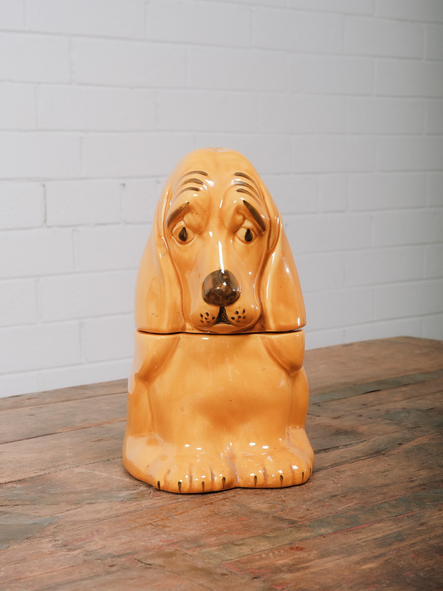Vintage Ceramic Hound Dog Cookie Jar: Vintage ceramic cookie jar in the form of a seated hound dog with expressive features and a warm caramel glaze. A classic mid-century kitchen collectible that makes a charming decorative accent while