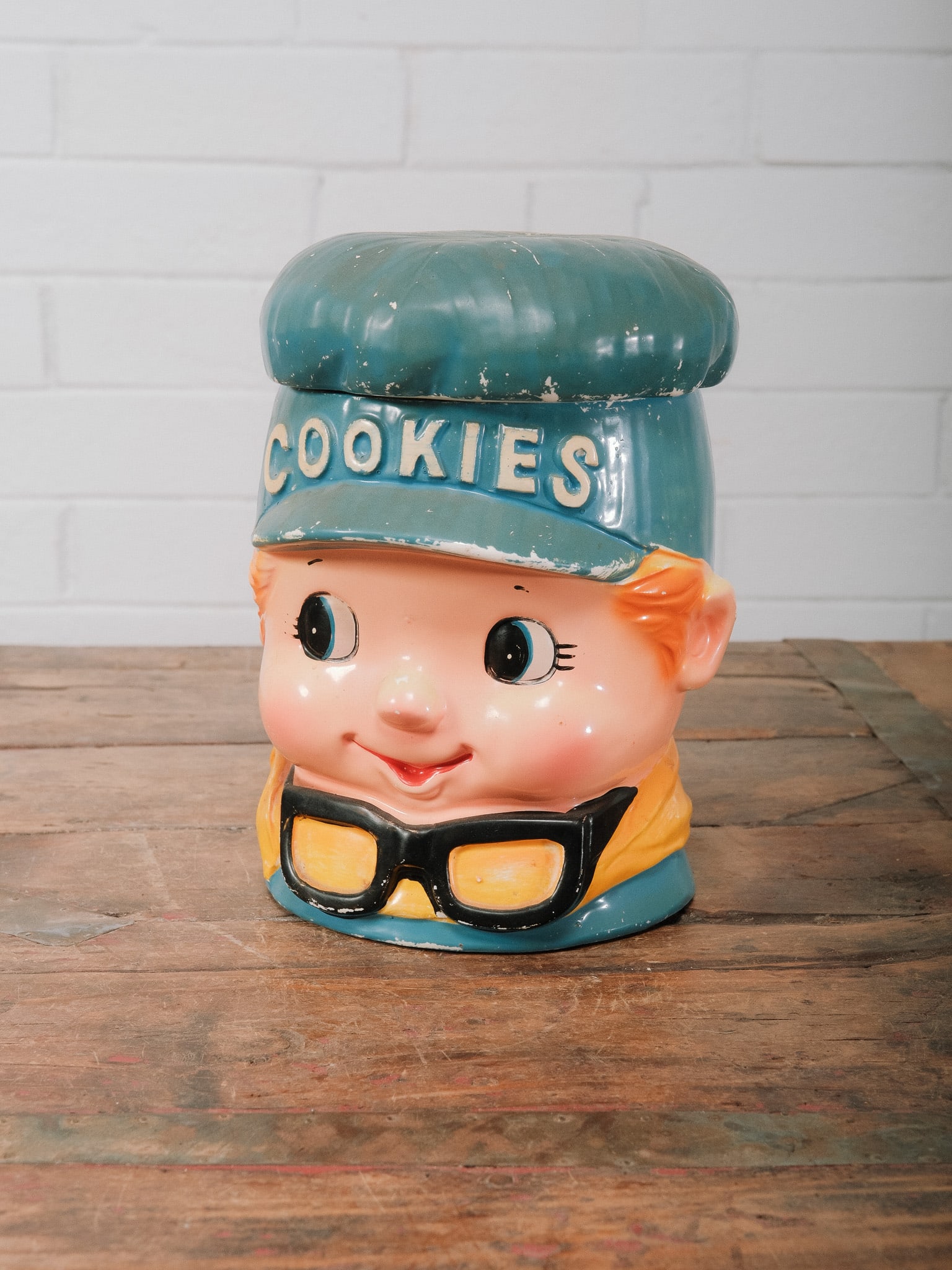 Vintage Boy Cookie Jar: Charming vintage ceramic cookie jar modeled as a smiling boy wearing a blue cap embossed with "COOKIES," complete with oversized glasses and colorful hand-painted details. A whimsical kitchen
