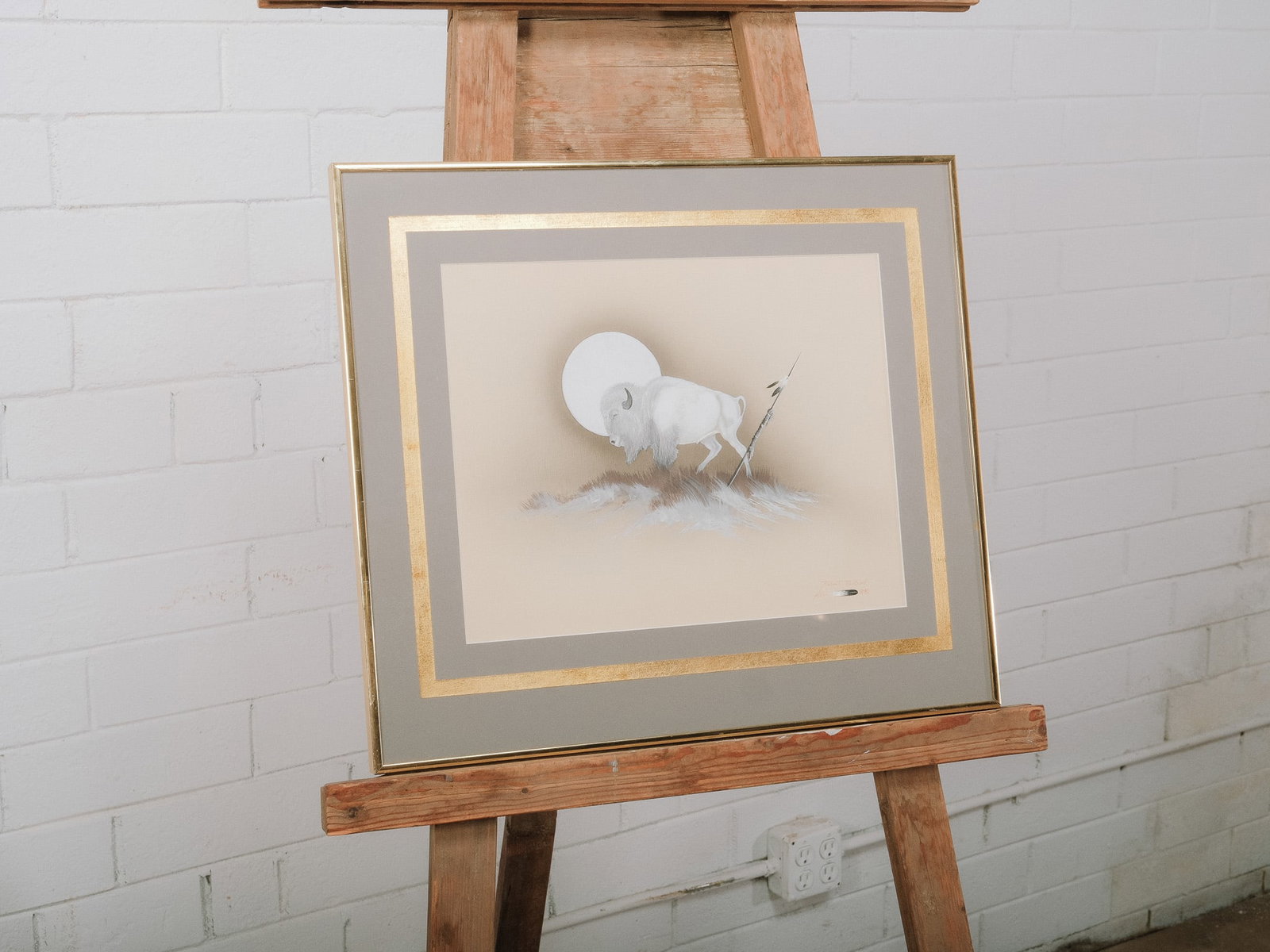Framed Buffalo Charcoal & Pastel Artwork: Framed wildlife artwork depicting a buffalo in a realistic style, rendered in charcoal and pastel with soft neutral tones. Double matted with gold-tone accents and presented under glass in a