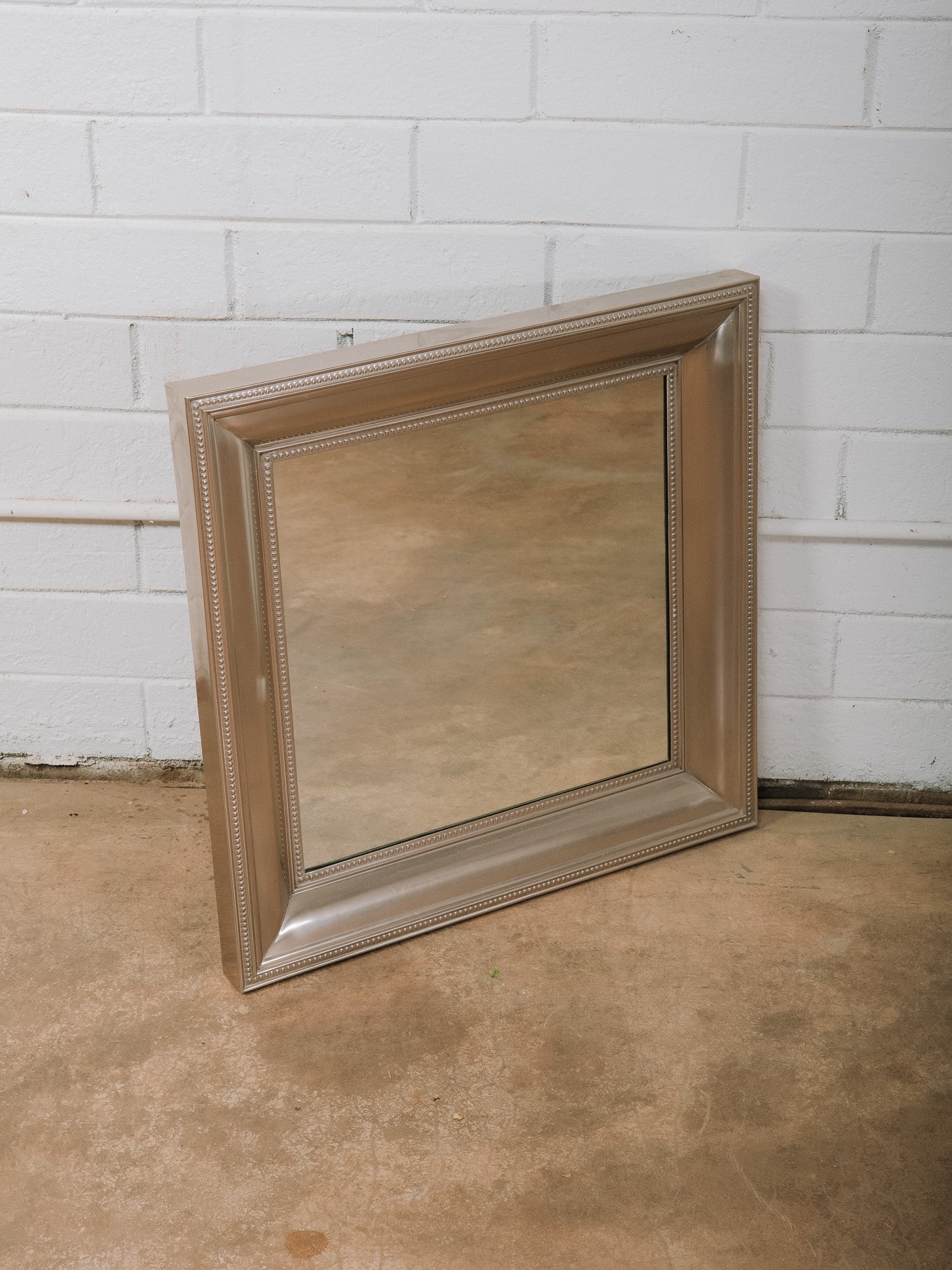Silver Framed Wall Mirror: Large wall mirror featuring a wide silver-finished frame with beaded inner detailing and a classic stepped profile. A versatile statement mirror suited for traditional, transitional, or contemporary