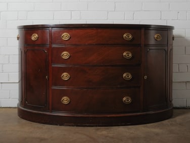Serpentine Mahogany Cabinet: Serpentine-front mahogany cabinet featuring a curved case with four central drawers flanked by two cabinet doors. Fitted with solid brass hardware.Approximate Dimensions: 36"h x 66"w x 23"d