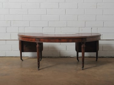 Crescent Drop-Leaf Writing Table: A charming crescent drop-leaf writing table featuring versatile drop leaves on both sides. It boasts a beautifully embossed leather top and includes a convenient central drawer. The table is