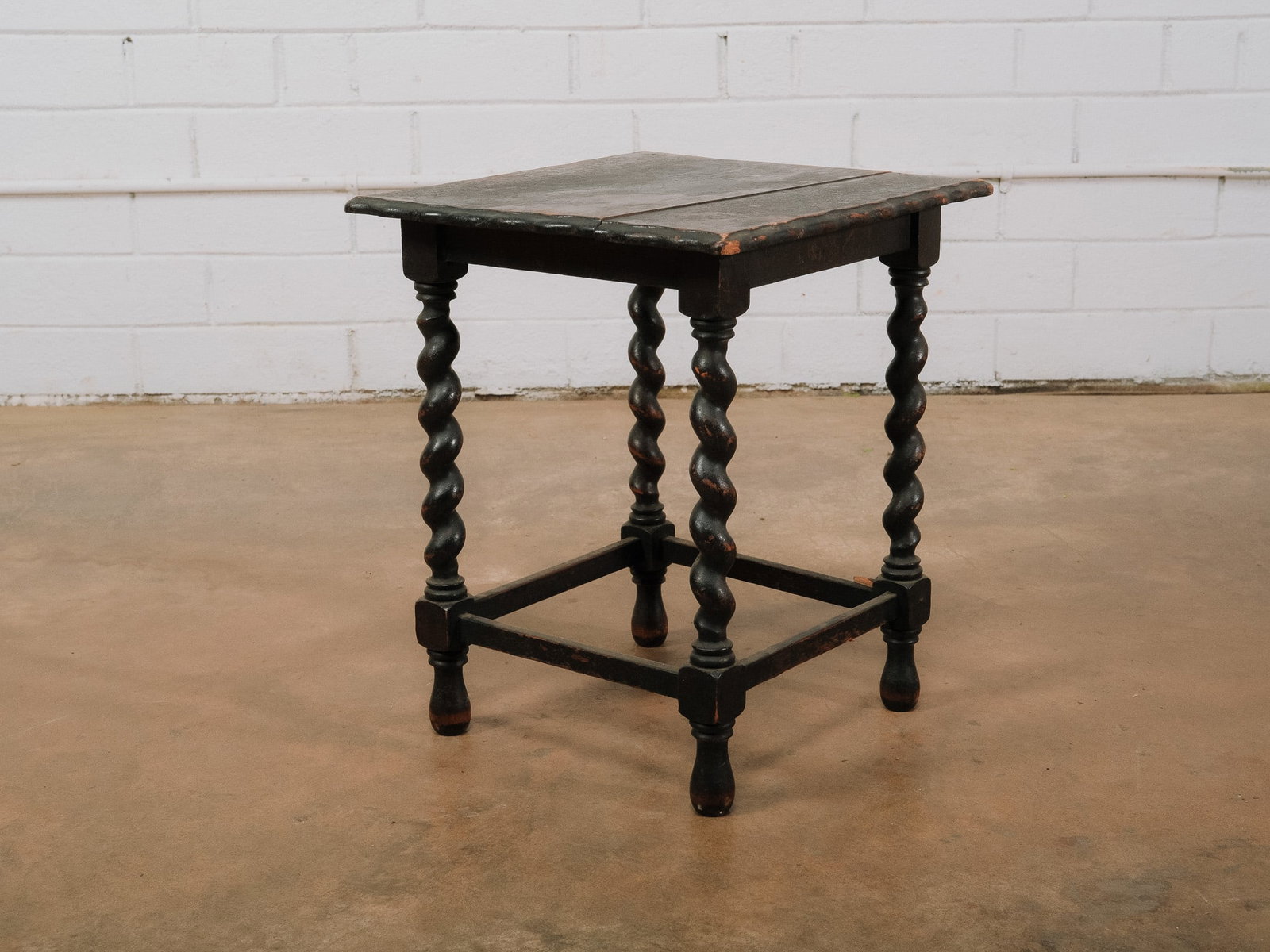 English Barley Twist Accent Table: English-style accent table featuring a square top supported by four barley twist legs joined by a box stretcher. Finished in a dark ebonized wood, this versatile table works well as a side table,