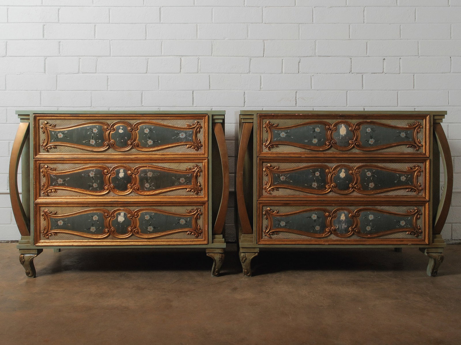 Pair of Venetian Style Commodes: An beautiful pair of hand-painted commodes in the elegant Venetian style, each featuring three spacious drawers for added functionality.Approximate Dimensions: 31"h x 38"w x 19.5"d