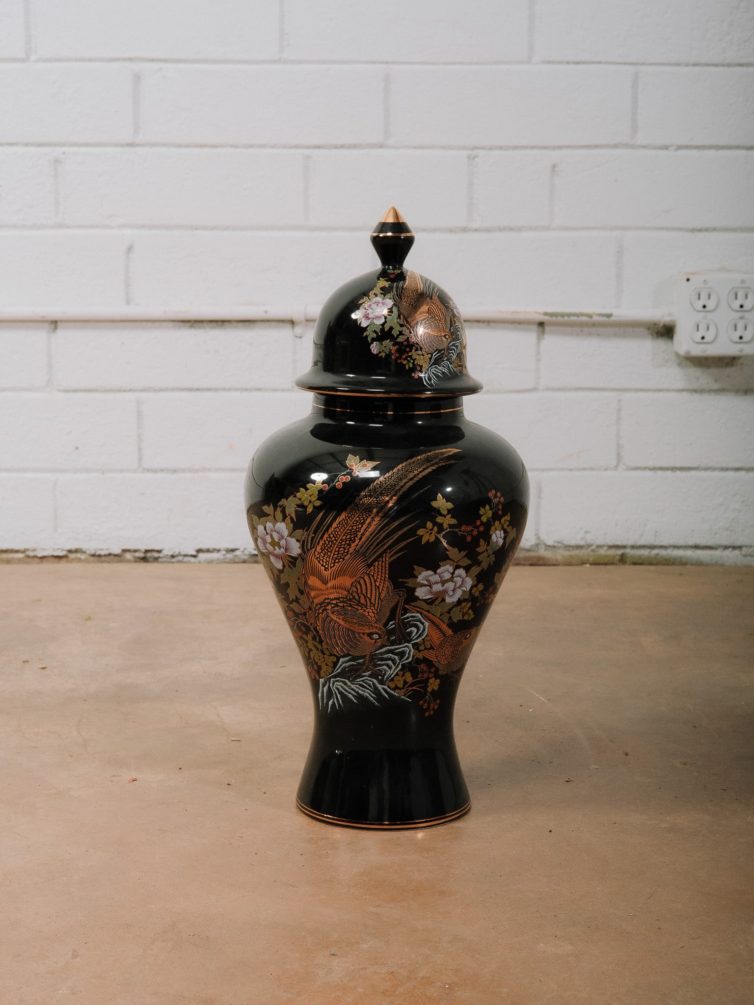 Japanese Black Lacquer Ginger Jar: Japanese black lacquer ginger jar featuring hand-decorated gilt pheasants, flowering branches, and colorful floral motifs. Finished with a matching lidded finial, this decorative vessel makes an elega