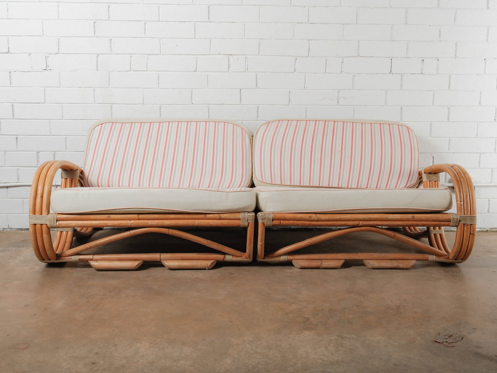 MCM Two-Piece Modular Rattan Sofa: This mid-century modern sofa is composed of two modular rattan seating units that can be arranged together or used separately. Each piece features a sculptural rattan frame with rounded arms and