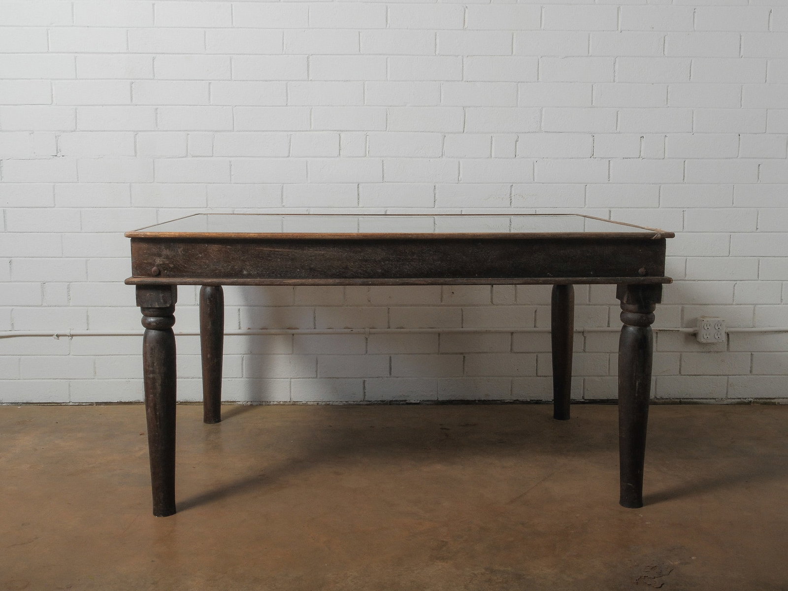 Carved Dining Table with Glass Top: Large handcrafted wood dining table featuring an intricately carved openwork top with an elaborate floral and foliate motif beneath a custom glass surface. The substantial frame is supported by turned