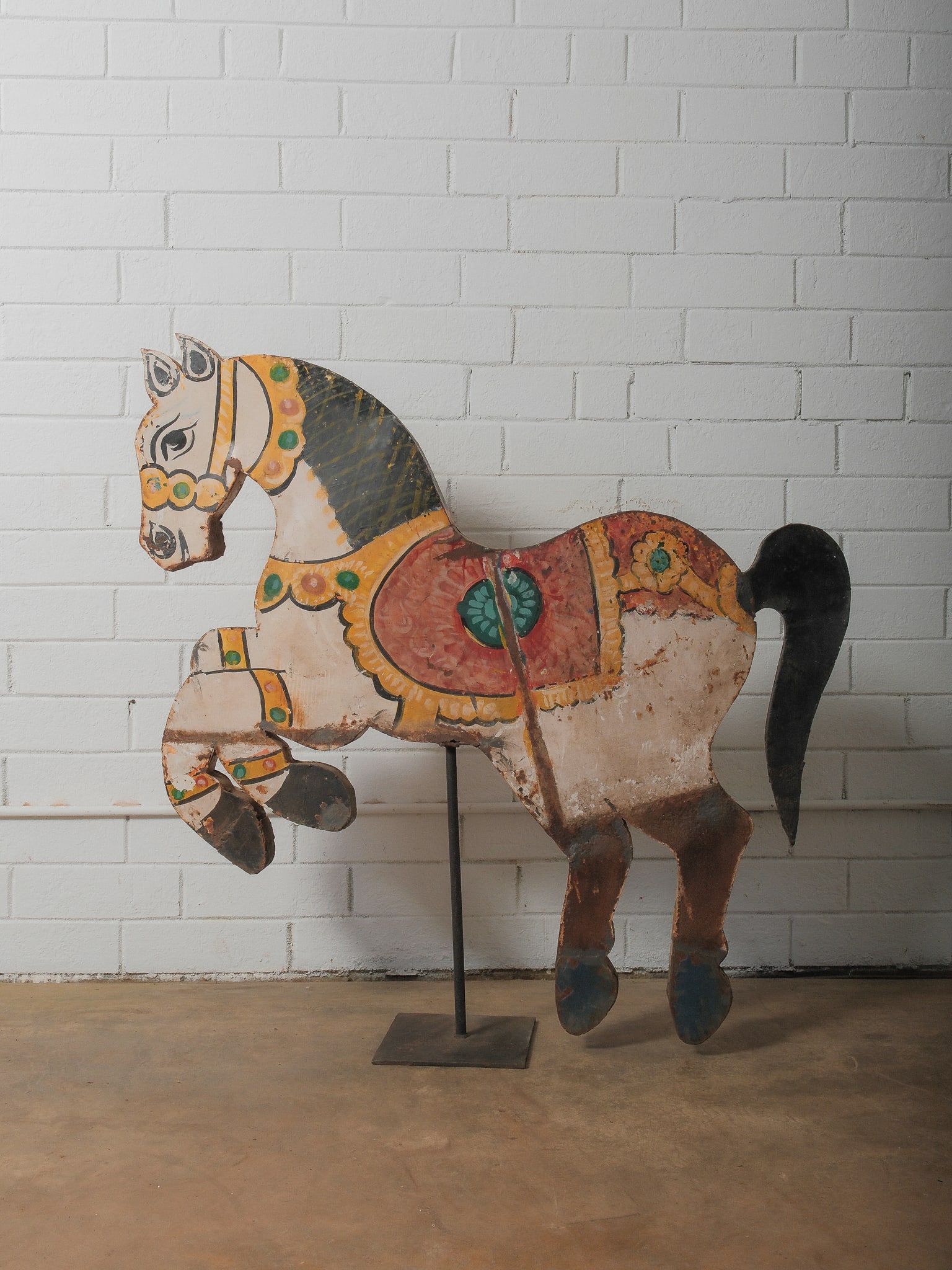 Antique Hand-Painted Carousel Horse Figure: Whimsical flat-profile carousel horse cutout with vibrant original paint and ornate saddle detailing. Mounted on a metal stand for display. Charming wear, chips, and patina consistent with age and