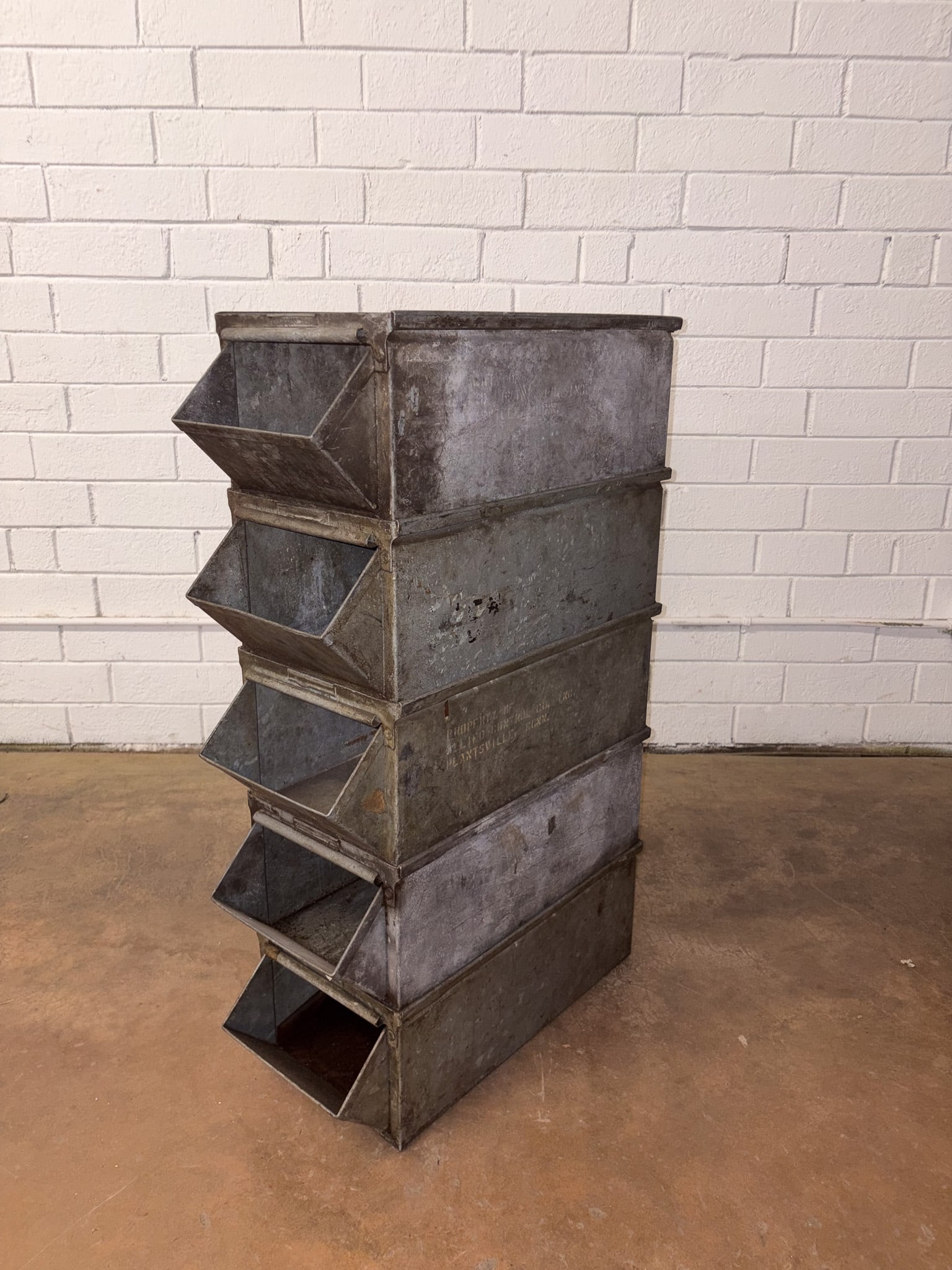 Set of 5 Metal Bins: Vintage stackable steel bins with embossed branding and a rugged industrial look. Approximate Dimensions: 8"h x 10.5"w x 23.5"d