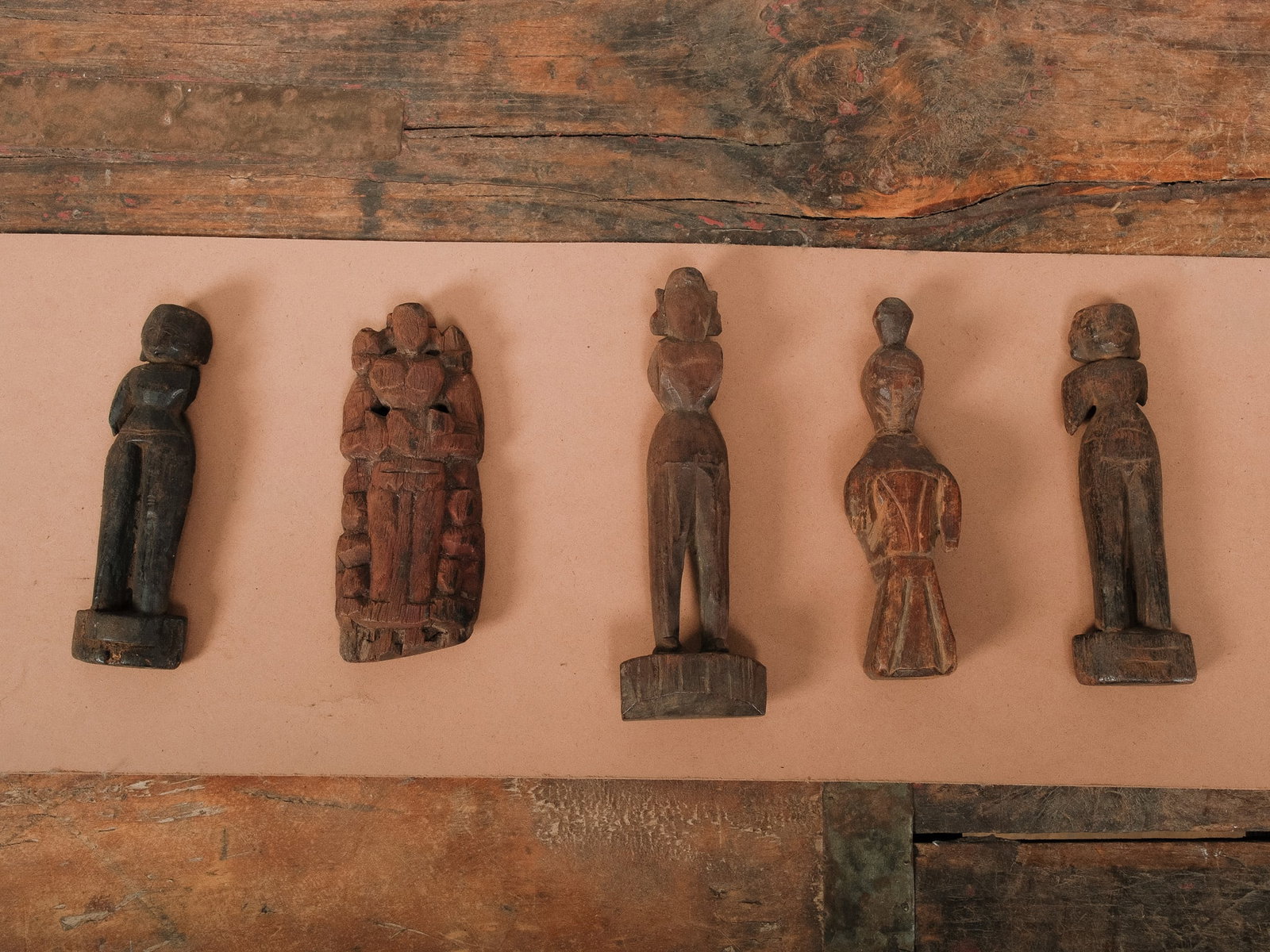 Group of Hand-Carved Tribal Figures: Collection of five hand-carved wooden tribal figures, each uniquely stylized with expressive forms and aged patina. A striking set for rustic or ethnographic display.Approximate Dimensions: 8"h x 3"w