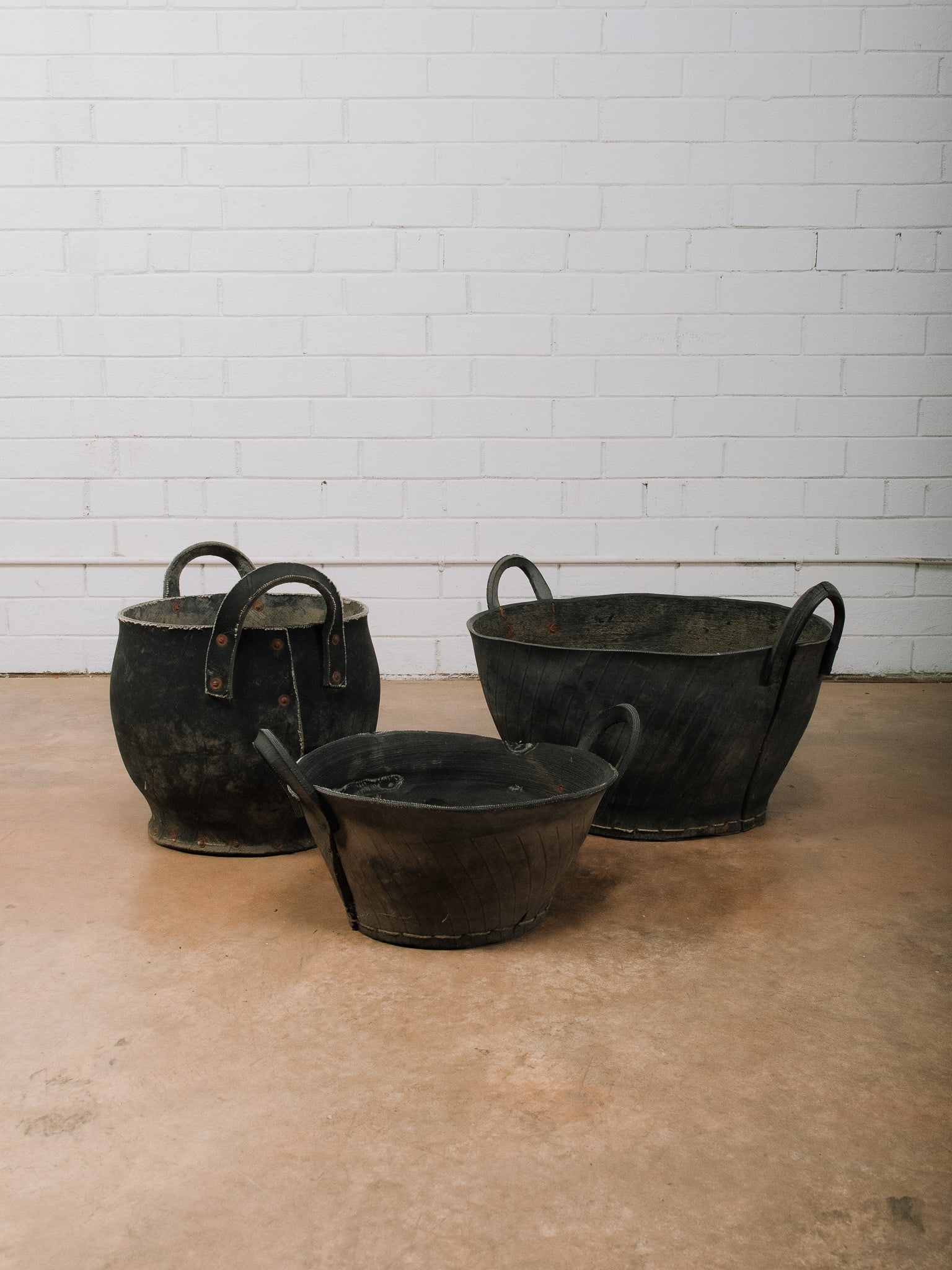 Group of 3 Rubber Buckets: Group of three vintage rubber buckets featuring flexible black rubber construction with sturdy integrated loop handles in assorted sizes. Originally designed for heavy-duty utility use, these versatil