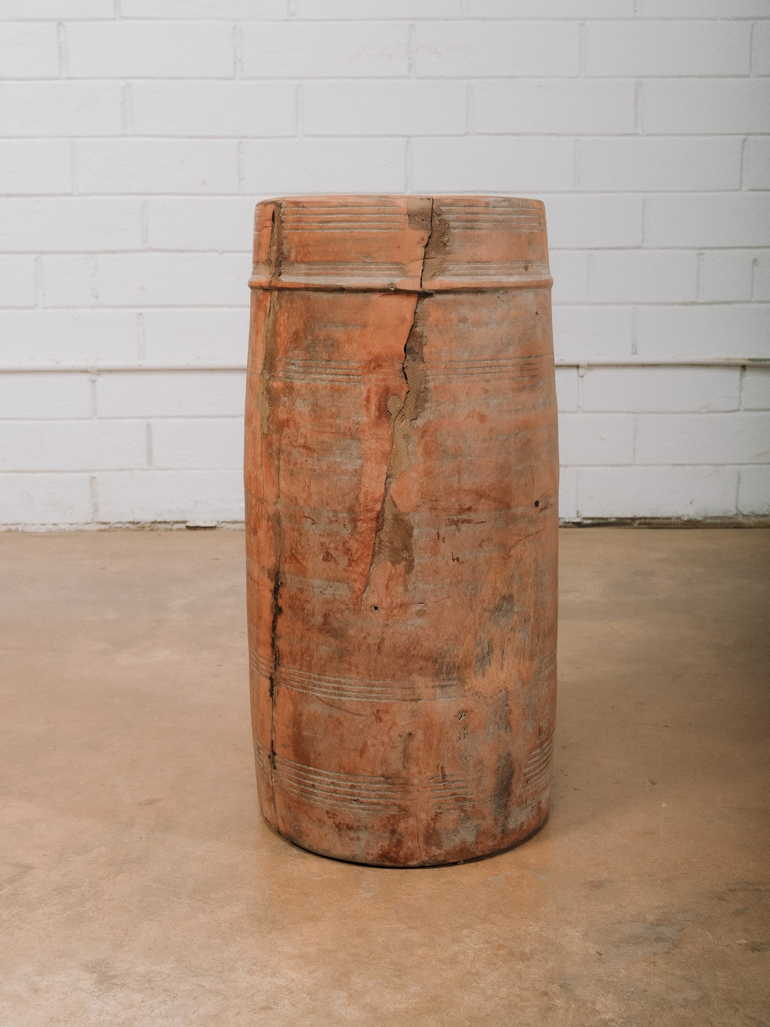 Large Carved Wooden Vessel: Large hand-carved wooden vessel featuring a cylindrical form with incised banding at the rim and base. The weathered surface displays a warm natural patina with visible age and character, including a