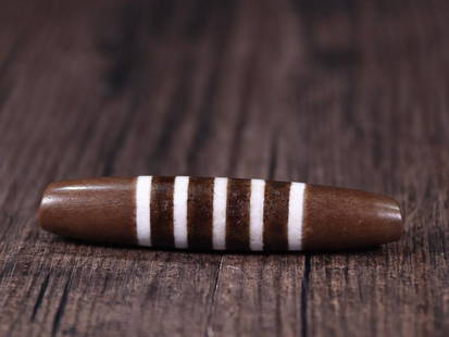 DZI BEAD: 7.32*1.47cm Description Statement: Any description statement is given as a courtesy to a client, is an opinion and should not be treated as a statement of fact and Merces Gallery shall have no