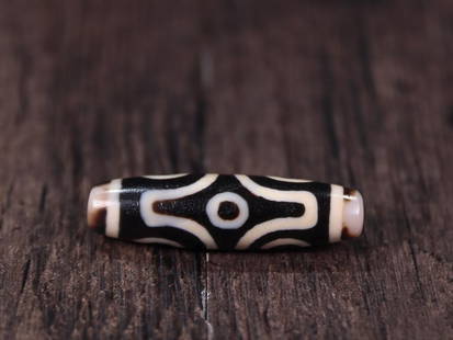 DZI BEAD: 4.75*1.31cm Description Statement: Any description statement is given as a courtesy to a client, is an opinion and should not be treated as a statement of fact and Merces Gallery shall have no