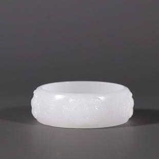 HETIAN JADE BANGLE WITH CARVED 'ANIMAL MASK': Thickness 0.7X1.9cm/ Inner-Diameter 4.5cm/ Weight 37g Description Statement: Any description statement is given as a courtesy to a client, is an opinion and should not be treated as a statement of