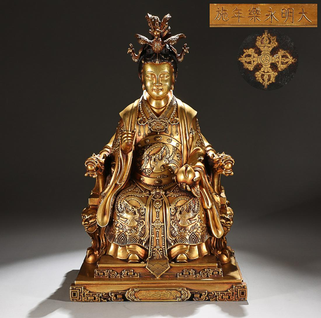 CHINESE GILT-BRONZE FIGURE, 'XI WANG MU', 'MING YONGLE' MARK: Height: 48cm, Width: 28.5cm. Weight: 16.1kg Description Statement: Any description statement is given as a courtesy to a client, is an opinion and should not be treated as a statement of fact and Merc