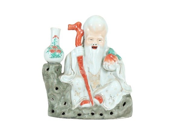 A CHINESE PORCELAIN OF SHOU LAO VASE: CIRCA 1900Carved as sitting on a pierced rockwork base, holding a tall staff in his right hand, wearing long robes,holding a peach in his left hand.beside him with one vase.Measure:9.6 x 8.1 x 3.5 inc