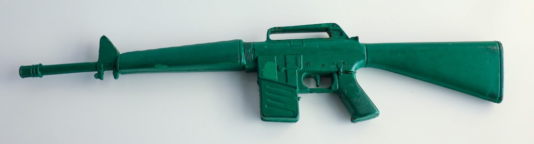 Green Army Men Prop Gun California Adventure Rifle: Prop gun used by the Green Army Men. Gun has heavy wear from time in service. Some discoloring and damage. Made of hard rubber. Measures 31 1/2" x 6 1/2"