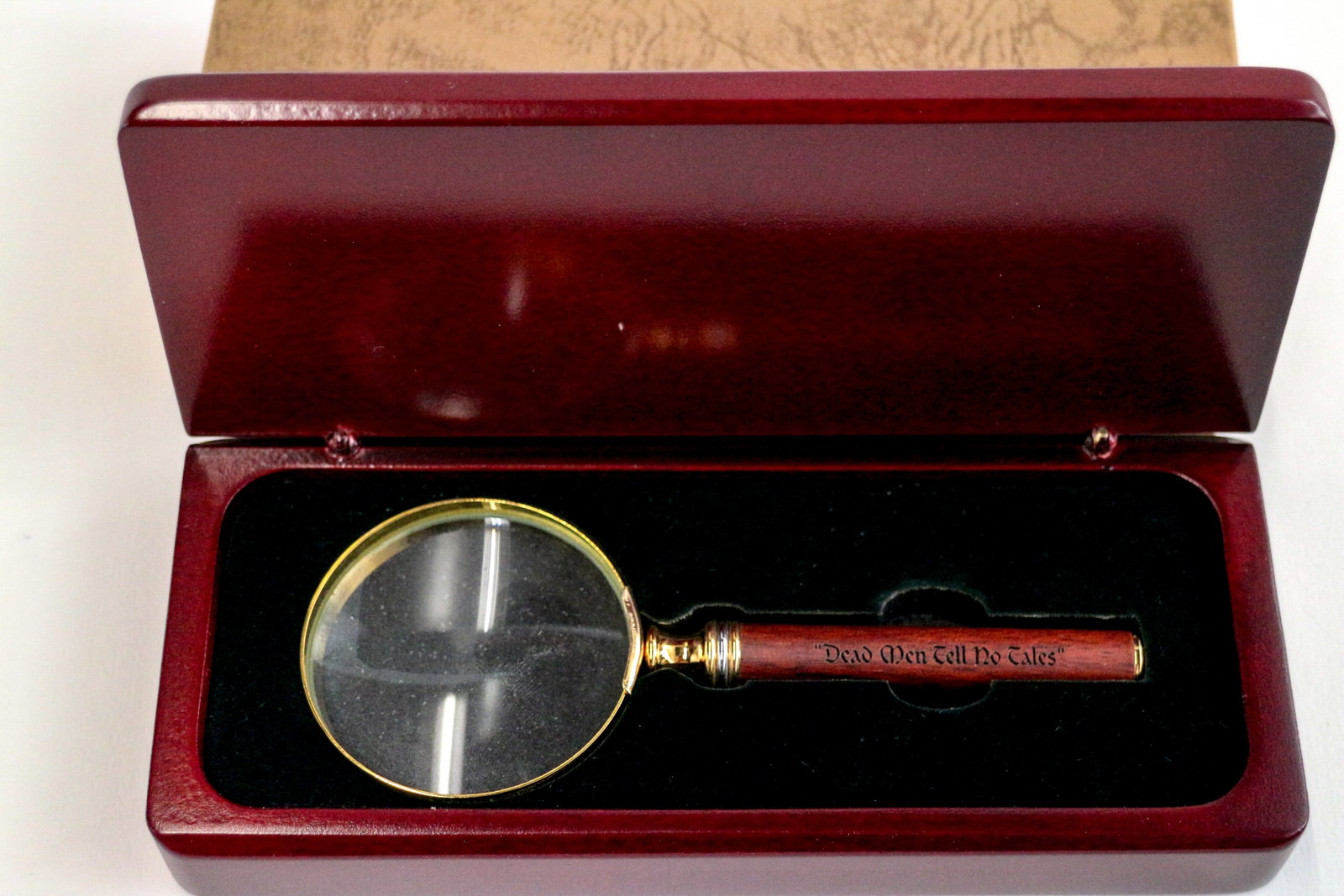 Pirates of the Caribbean "Dead Men Tell No Tales" Magnifying Glass.: (Disneyland, 2003) Reminiscent of the magnifying glass the skeletal remains of the Pirate Captain holds in his Captain's Quarters bed, this is a very rare "Dead Men Tell No Tales" engraved magnifying 