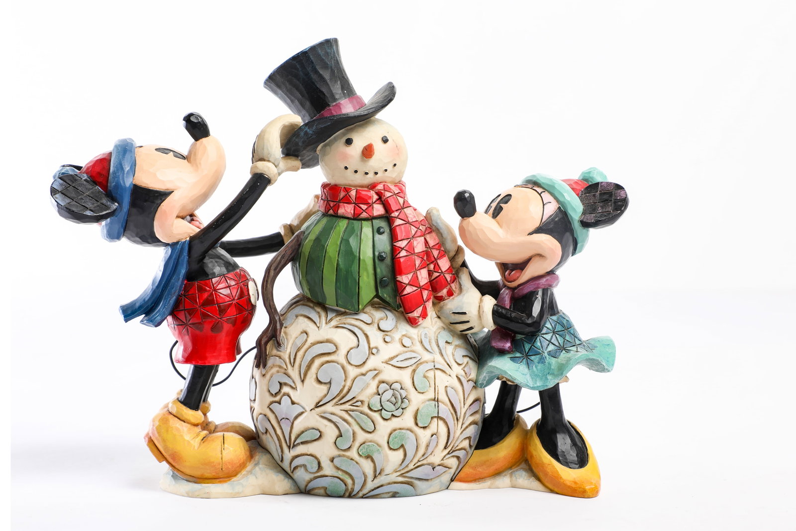 Jim Shore Disney Traditions - Mickey and Minnie Mouse “Dressing Up For The Holidays” Figure: Mickey and Minnie place a few final, fashionable touches on their snowman for the 2009 Jim Shore Disney Traditions "Dressing Up For The Holidays" Figure! Measuring approximately 7” tall and 8&rd