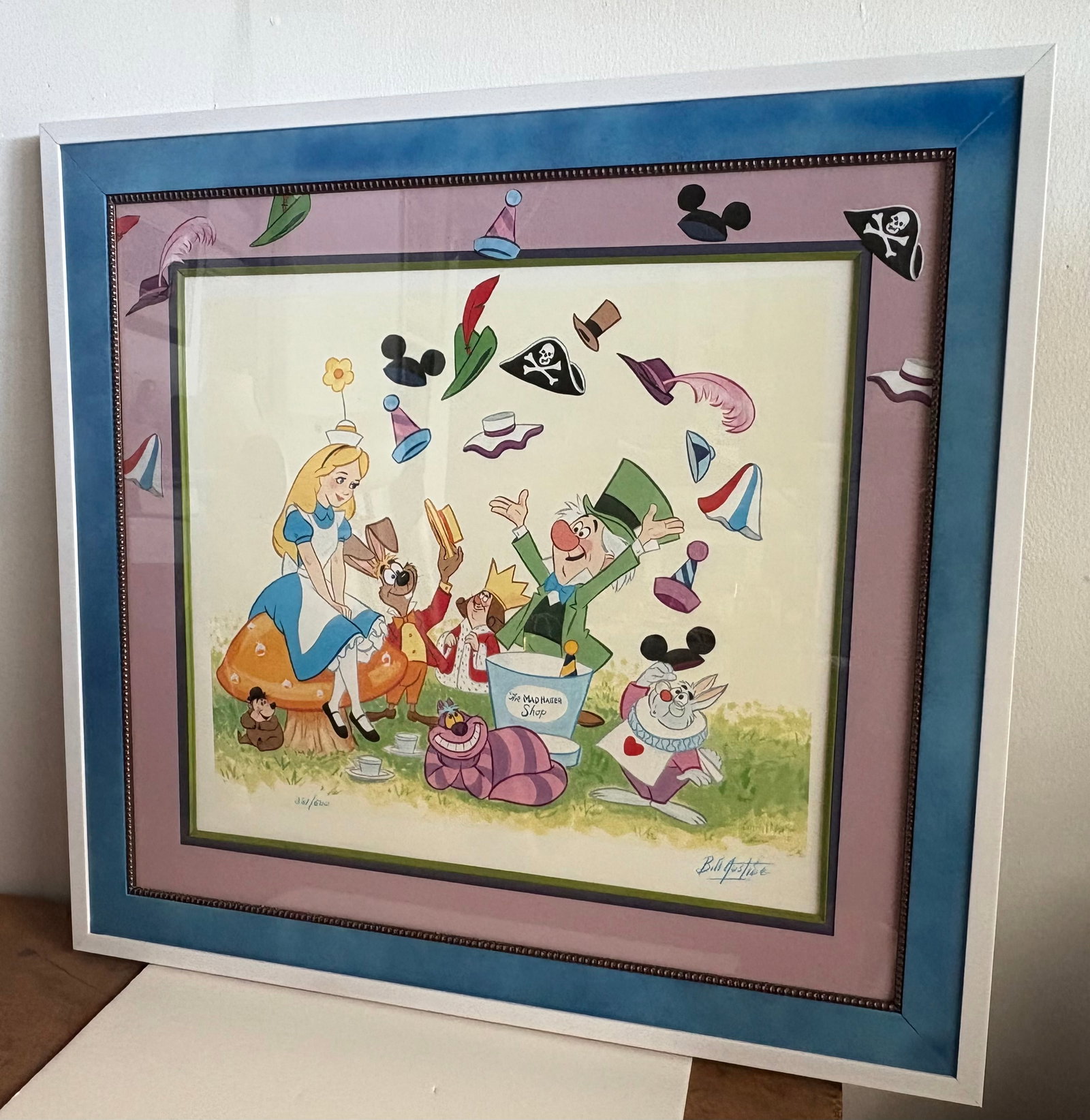 Disneyland - "Mad Hatter Shop" LE Print Signed by Bill Justice #381/500 (Walt Disney, 1995).: The namesake proprietor touts an assortment of souvenir hats in this Disney Gallery exclusive, sold-out, limited-edition celebration of the memorable mural inside The Mad Hatter Shop at Disneyland Par