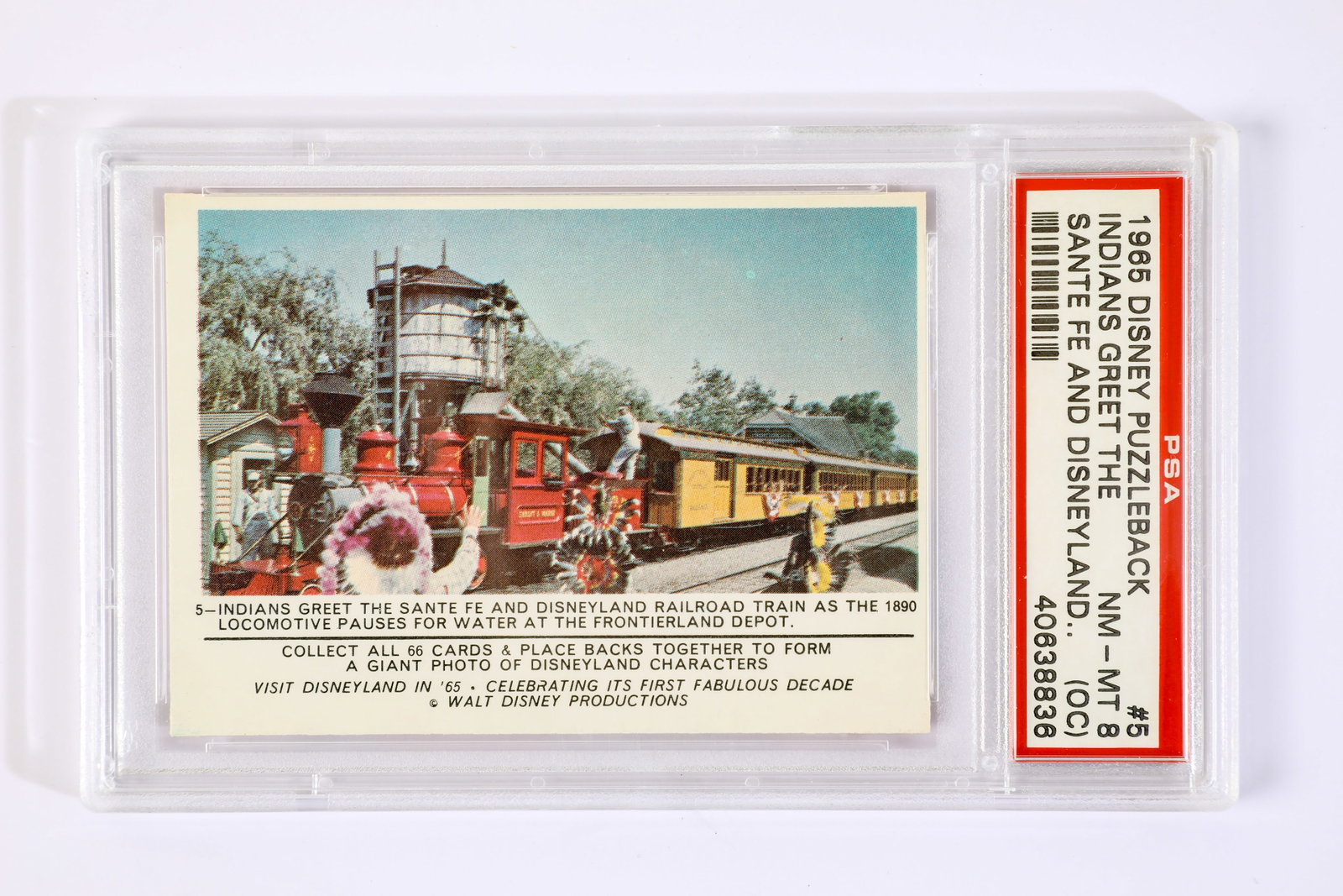 Donruss Disneyland Card #5 Indians Greet the Santa Fe PSA (NM-MT 8) (1965).: “Indians greet the Santa Fe and Disneyland Railroad train as the 1890 locomotive pauses for water at the Frontierland Depot.” This vintage, collectible Donruss Disneyland Card #5 showcases the