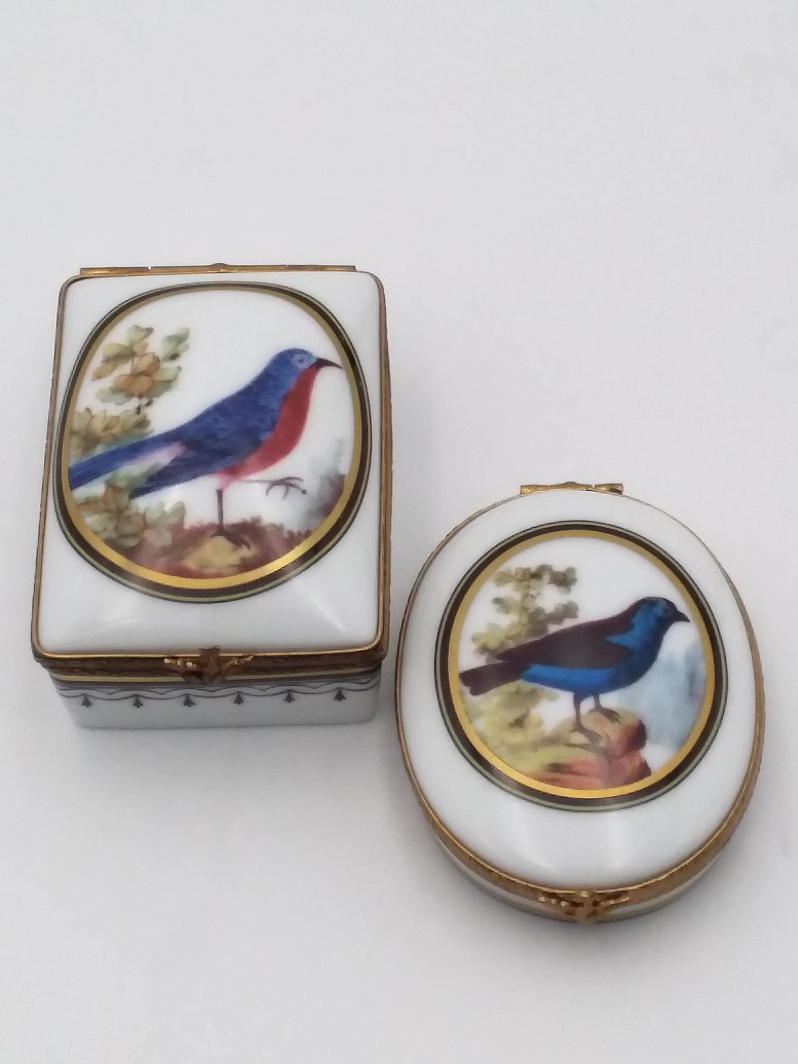 2 Limoges Trinket Boxes by Ancienne Manufacture Royale: Hand Decorated Bird Motif Limoges Trinket Boxes by Ancienne Manufacture Royale. Two Boxes one oval & another rectangular and size for the rectangular piece is 1 inch tall x1 3/4 x 2 1/2. oval box is 1