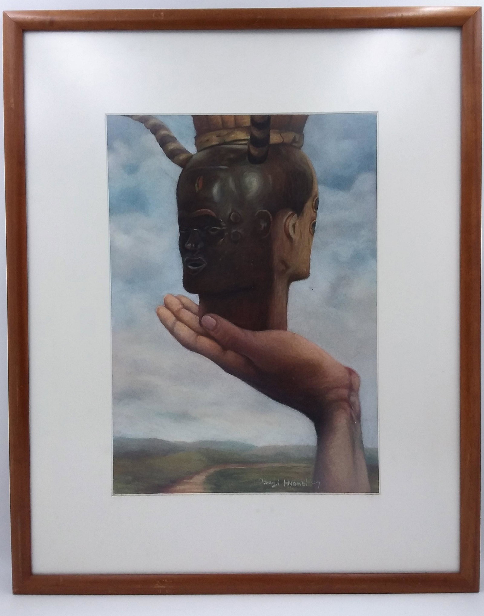 1997 Obaji Nyambi (Nigerian-1960) Watercolor: A Surrealist Watercolor Depicting an African Mask on a hand. Signed & Dated on the bottom left hand. Visible image size is approximately 15.5 inches tall x 11 inches wide.About the artist: Born 1960, 
