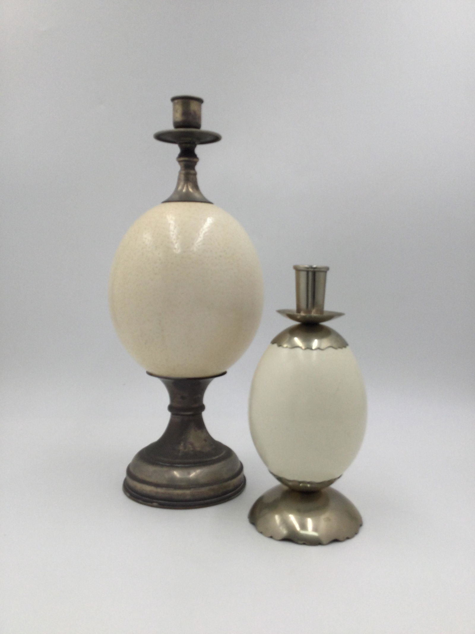 1970 Pair of Silver Plate Candle Holders W/Ostrich Eggs: Two Silver Plated Candle Holders with Ostrich Egg centers. Approximate size 12.5 & 7.5 inches tall each, combined weight approximately 8 pounds. Free pick-up at our warehouse. Shipping is done by a 3r