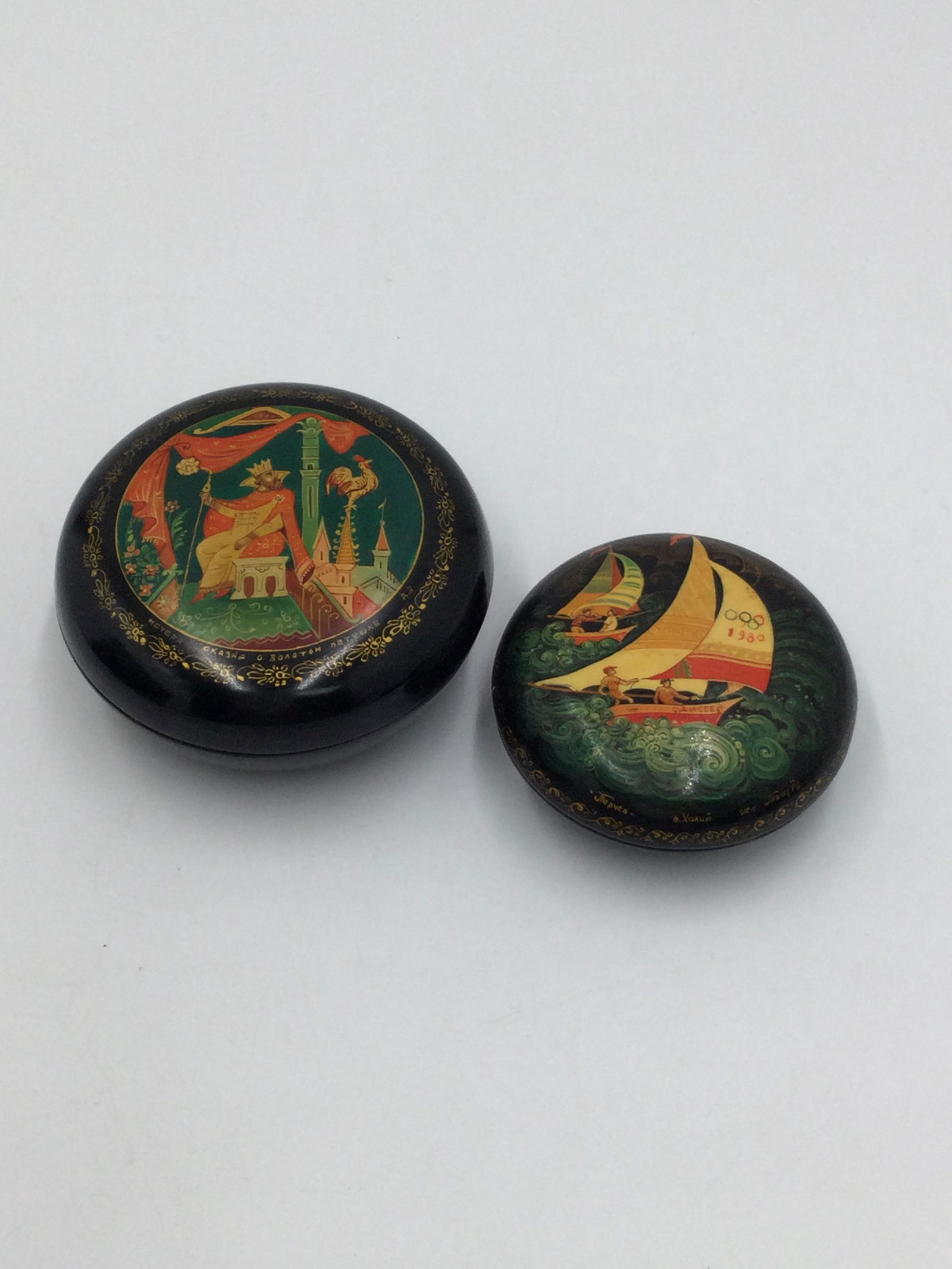 Lot of 2 Russian Lacquered Boxes Fairy Tales & Olympics: Lot of 2 small Russian Lacquer boxes - Fairy Tales & Olympic Games Themes. Each box is signed, please see photos. Both are round shape, 2.75 and 2.25 inches across. Free pick-up at our warehouse. Ship