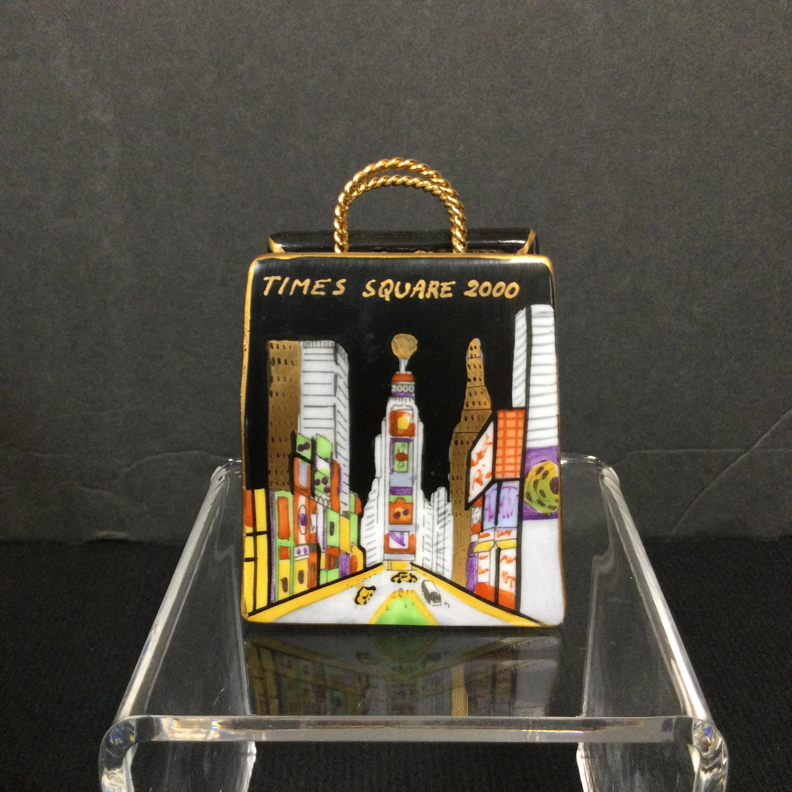 Limoges Time Square Millennium Trinket Box: Limoges Peint Main Porcelain Trinket Box Times Square 2000 Shopping Bag, signed CP. Approx. size 2.75 inches tall x 2 wide x 1-3/8 deep. Approx. weight 2.4 oz. IMPORTANT: In House Shipping.