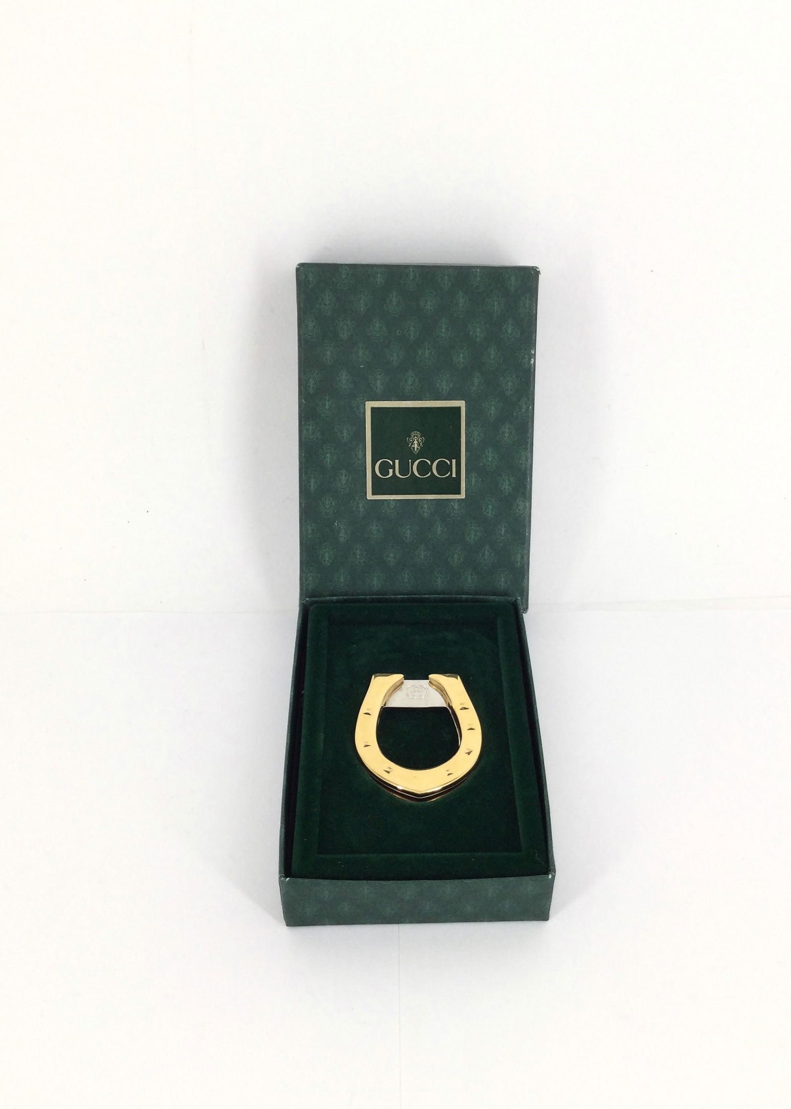 Italian Gucci Horseshoe Money Clip in Original Box: Gucci gold colored horseshoe money clip with original box. Approx. size 1.75 inches tall x 1.5 wide x 0.25 deep. Approx. weight 0.7 oz. IMPORTANT: NO In-House Shipping, Please read our shipping terms