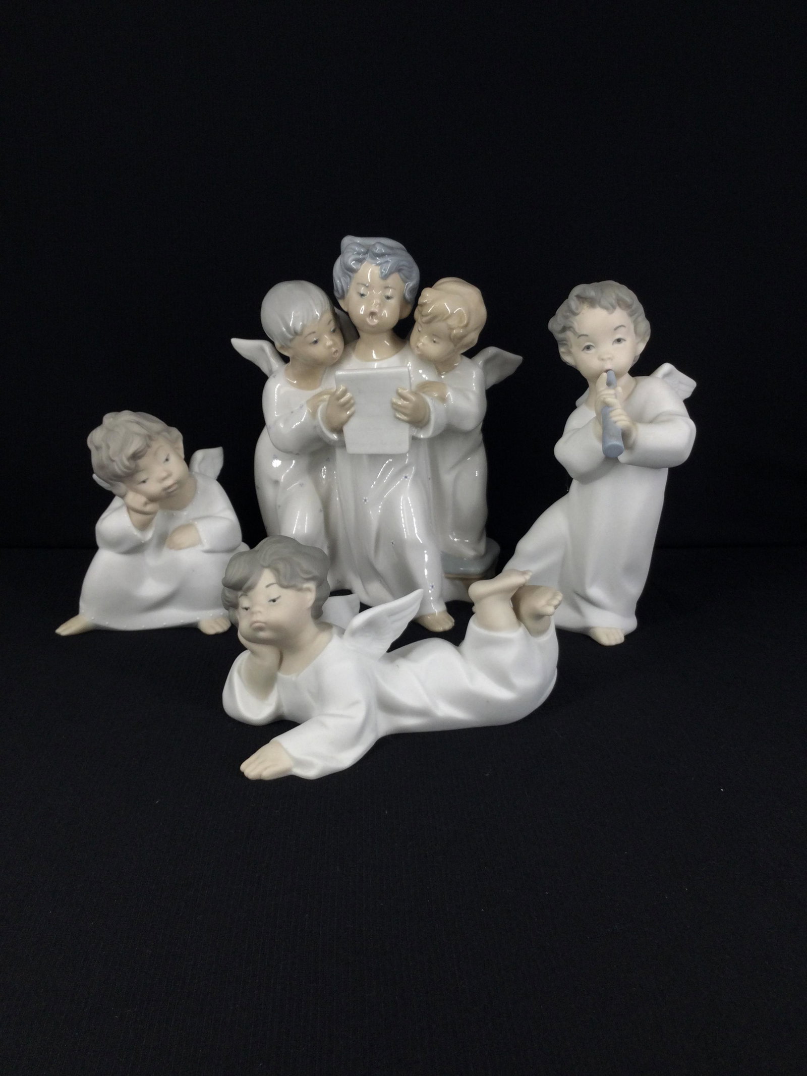 Lot of 4 Lladro Porcelain Figurines 4539, 4540, 4541, and 4542: Lot of 4 Lladro Porcelain Figurines. 4541 matte finish Angel Laying Down. 4539 matte finish Angel Thinking. 4540 matte finish Angel with Flute. 4542 gloss finish Three Angels Singing. Approx size 7 in