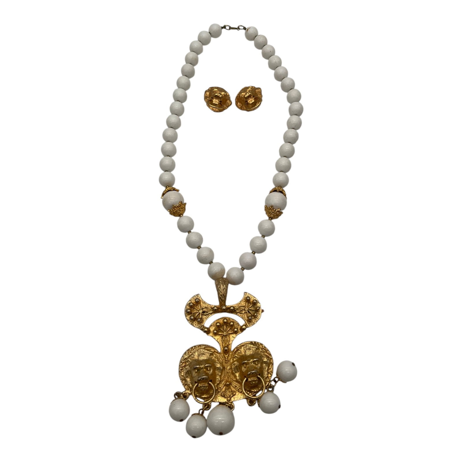 Jules Van Rouge Necklace and Earring Set: Jules Van Rouge matte gold lion door knocker statement pendant white beaded Necklace and lion head door knocker clip-on earrings Set. Approx. (earrings) 1.5 inches tall x 1 wide, (necklace) 25 inches 