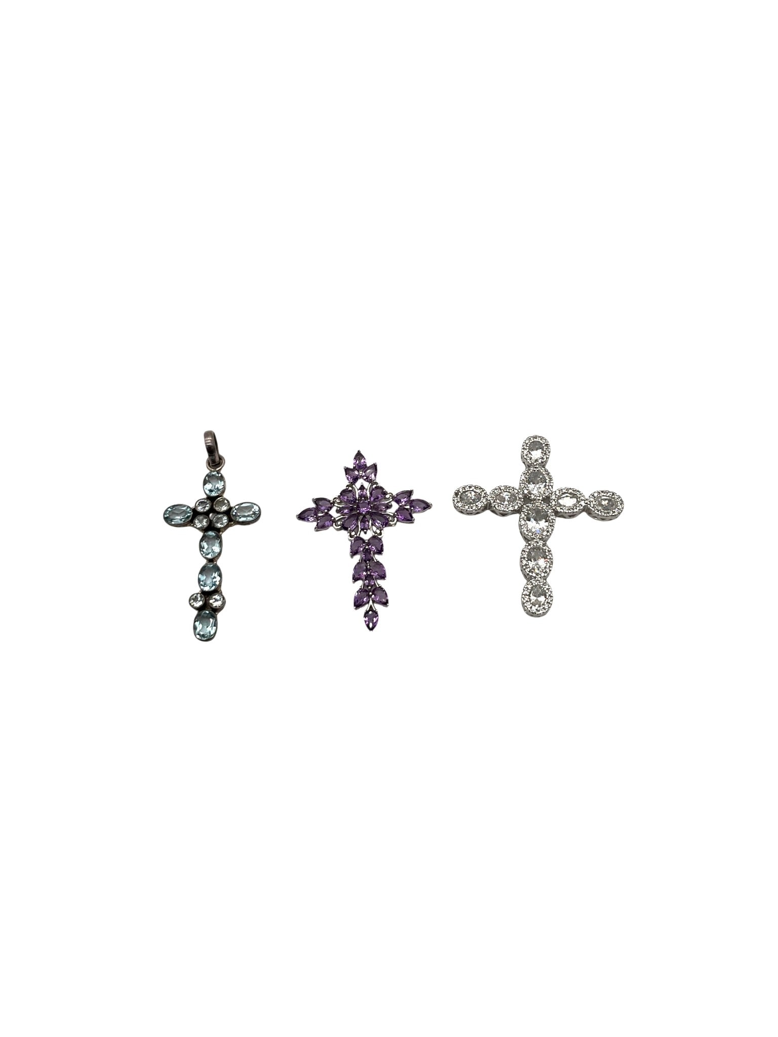 Lot of 3 925 Gemstone Crosses: Lot of 3 stamped 925 Gemstone Crosses. Approx. Clear CZ cross 2.25 T x 1 7/8 inches wide, Amethyst Cross 2 T x 1.5 inches wide, Blue Cross 2.5 T x 1 inch wide.