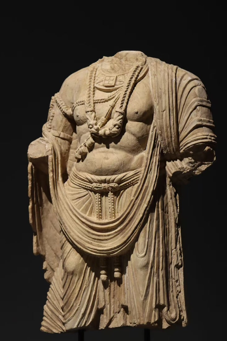THE REMNANTS OF A STANDING STATUE OF A BODHISATTVA FROM GANDHARA SLATE IN THE 3RD CENTURY: H:46cm This is a fragmentary torso of a standing Bodhisattva from the peak period of Gandhara art, a masterpiece blending Greco-Roman naturalism with Buddhist iconography.