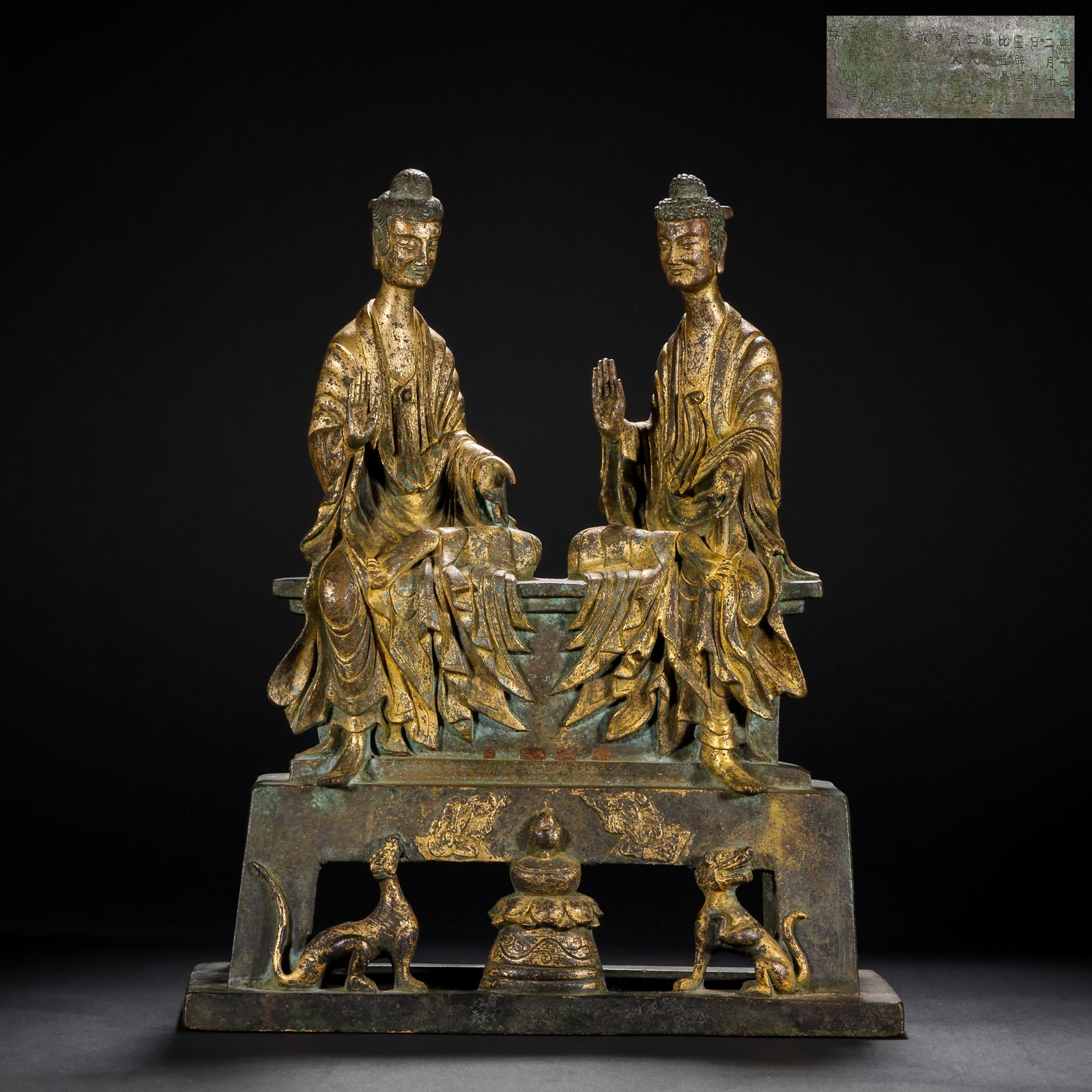 A GILDED BRONZE SEATED STATUE OF TWO BUDDHAS FROM THE NORTHERN WEI DYNASTY: H:33cm(12.99in) W:26.3cm(10.35in) Weight:5270g(11.62lb)This statue is cast in bronze and gilded. Two Sakyamuni Buddhas are seated together on the pedestal, with smooth robe folds, solemn appearances, 