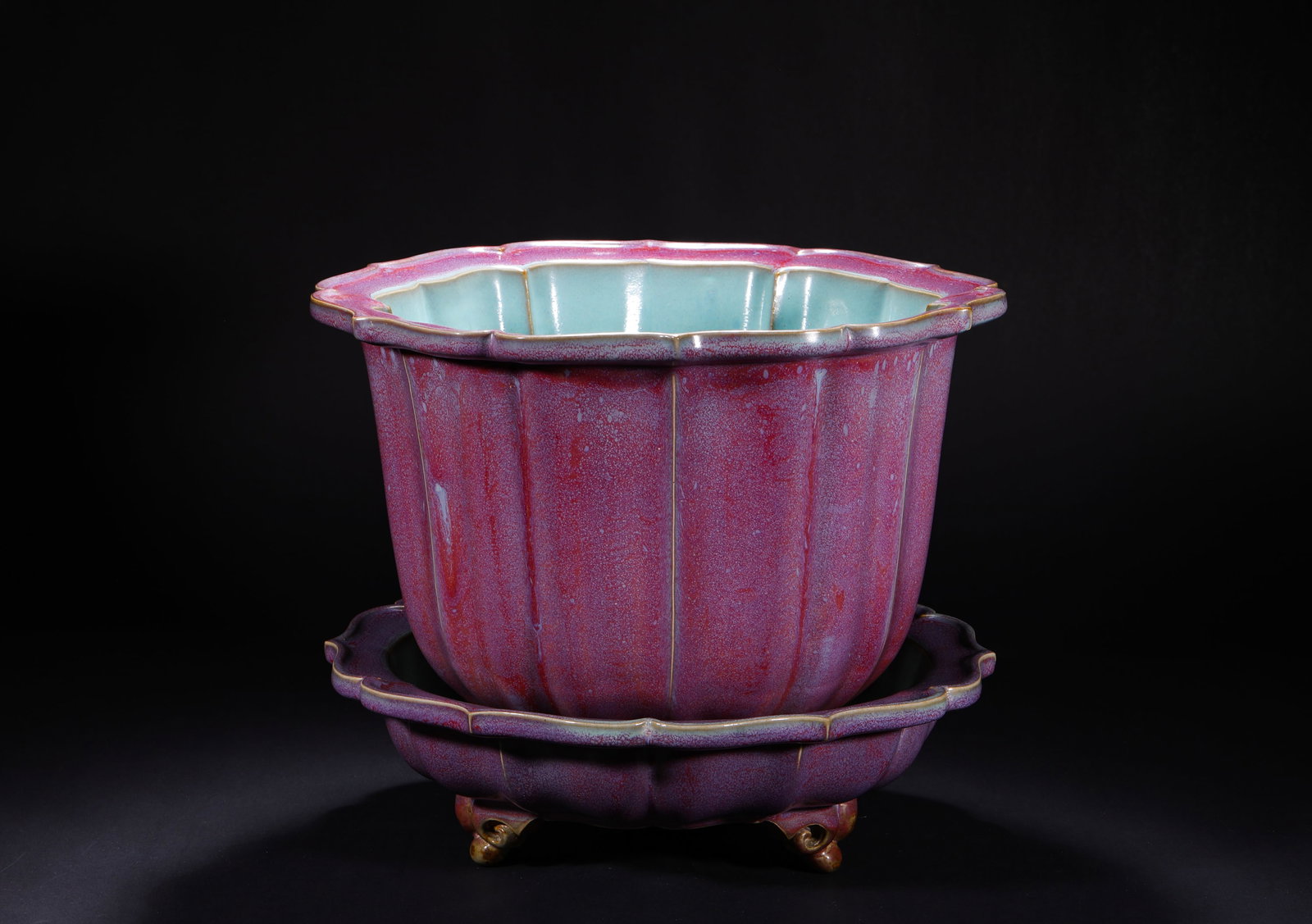 A ROSE PURPLE GLAZED SUNFLOWER FLOWERPOT FROM JUN KILN OF THE SONG DYNASTY: H:29.0cm(11.42in) W:34.0cm(13.39in)This flower pot is a classic imperial form of the Song Dynasty Jun Kiln, featuring a sunflower-flared mouth, ribbed melon-shaped body, and a matching three-footed st