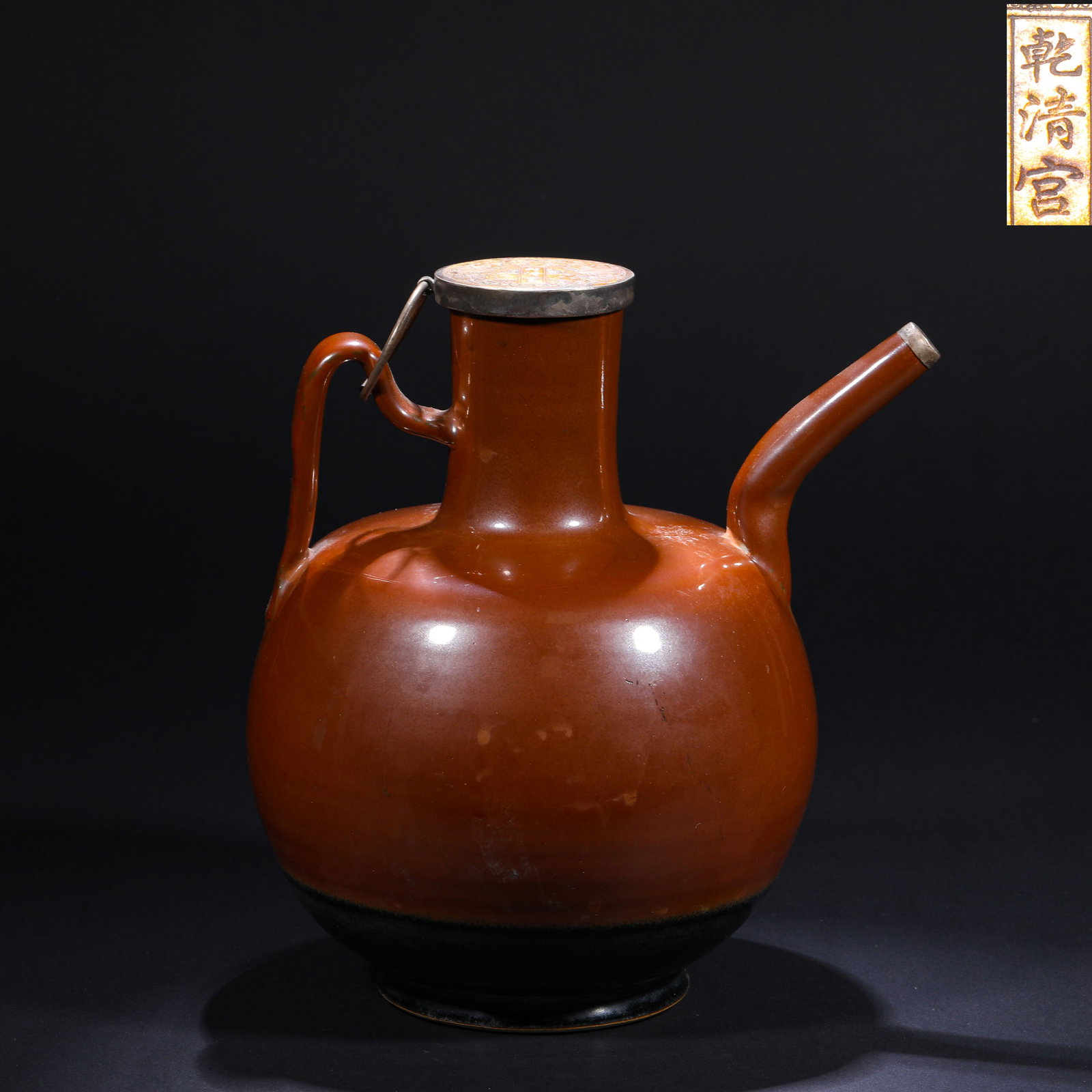 DING KILN SAUCE-GLAZED EWER OF THE SONG DYNASTY: H:25cm(9.84in)W:22cm(8.66in) This Song-Yuan period brown-glaze ewer, with a silver lid and "Qianqing Gong" mark, is a typical example of the integration of northern folk porcelain and Qing court colle