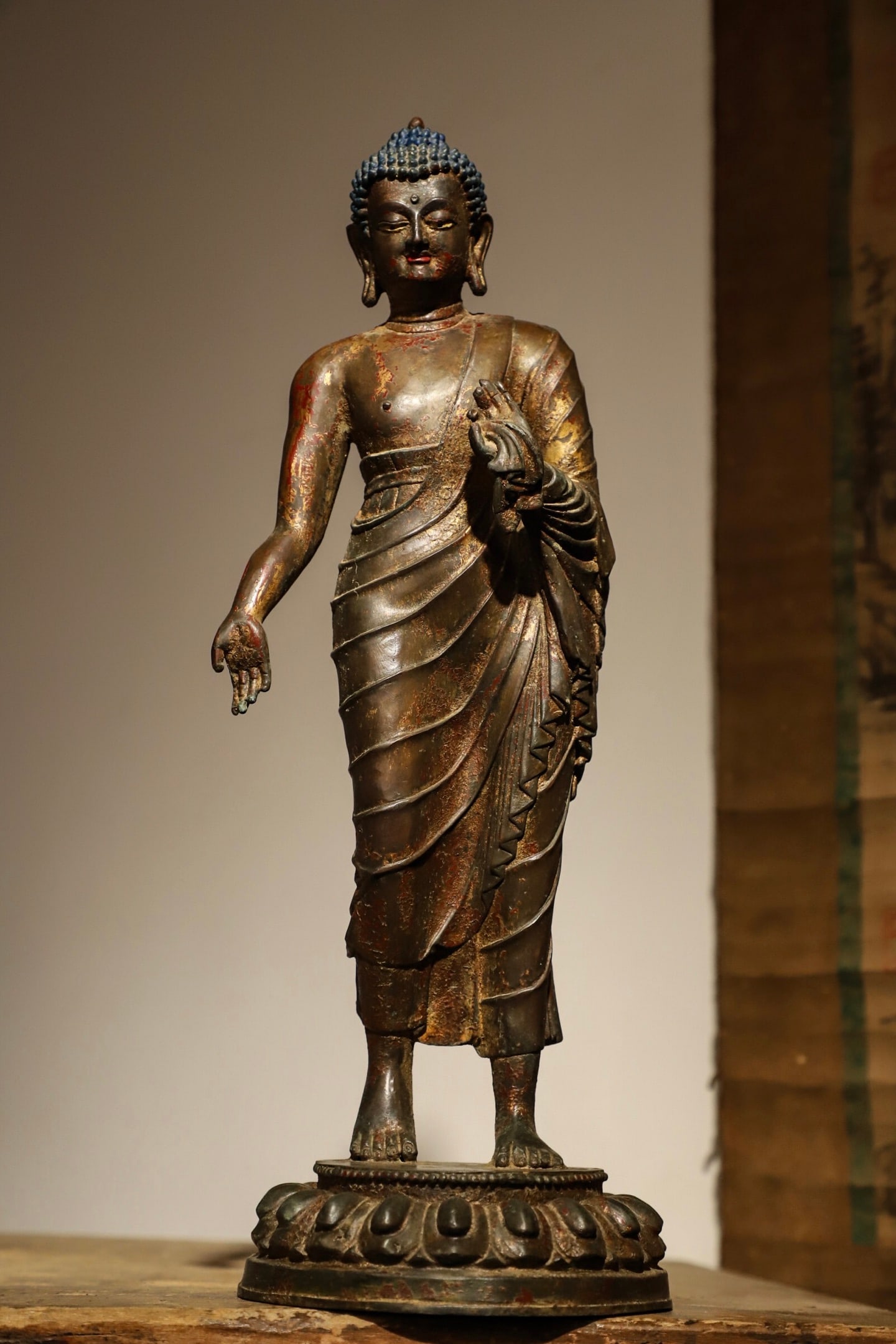A BRONZE GILDED SANDALWOOD BUDDHA STANDING FIGURE FROM THE MING DYNASTY: Weight:3500g(7.72lb) H:37cm(14.57in) D:12.5cm(4.92in) This is a gilded bronze standing statue of Sakyamuni Buddha from the Ming Dynasty. Cast from fine bronze with overall gilding and mineral