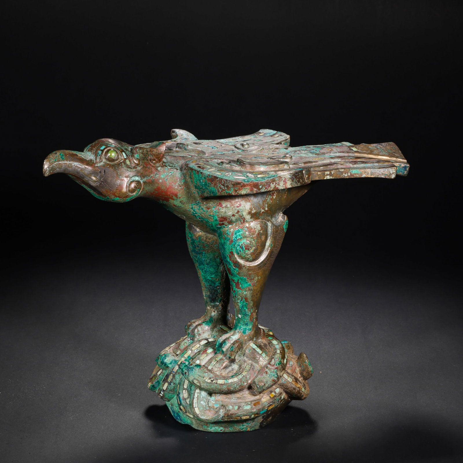 BRONZE INLAID WITH GOLD AND SILVER INLAID WITH GEMSTONES AND DIVINE BIRD TABLE FEET FROM THE WARRING: H:21.0cm(8.27in) W:30.0cm(11.81in) Weight:3110g(6.86lb)This artifact is cast in bronze, shaped as a divine bird with head held high and wings spread, standing on a gem-inlaid snake base. The bird's ey