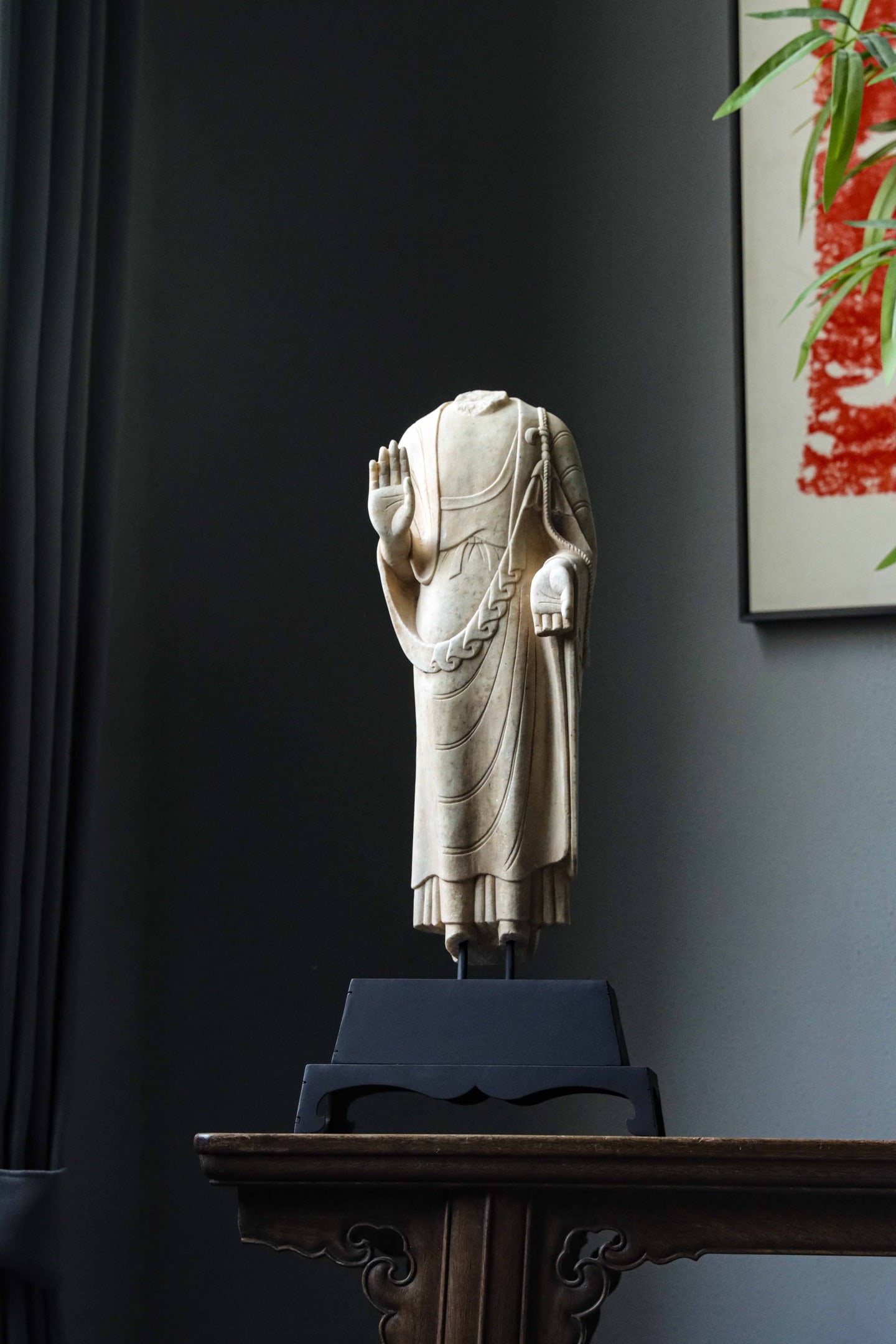 A STANDING STATUE OF A BROKEN BUDDHA IN WHITE MARBLE FROM THE NORTHERN QI PERIOD: H:48cm (18.90in)H:37cm (14.57in) W:14cm (5.51in) T:10cm (3.94in)lampstandH:11cm (4.33in) W:22cm (8.66in) T:17cm (6.69in)This is a fragmented statue of Sakyamuni Buddha with lost head and feet, featuri