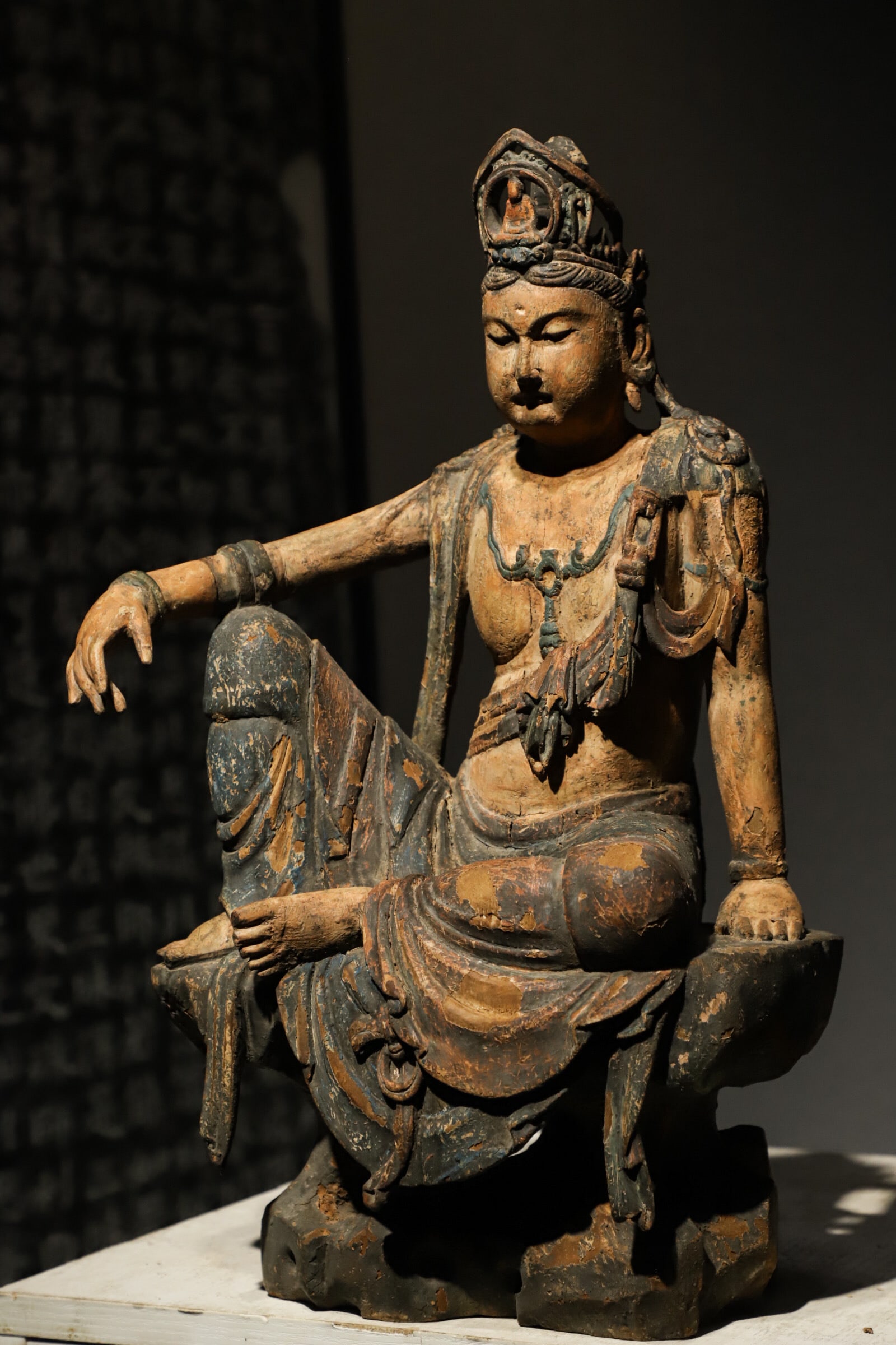 MING DYNASTY LACQUERED GOLD WOODCARVING. SEATED GUANYIN: H:46cm(18.11in)L:28cm(11.02in)W:20cm(7.87in)The solid ancient wood bears deep mild natural patina after centuries of erosion with well-preserved faded indigo pigment relics and profound weathered prim