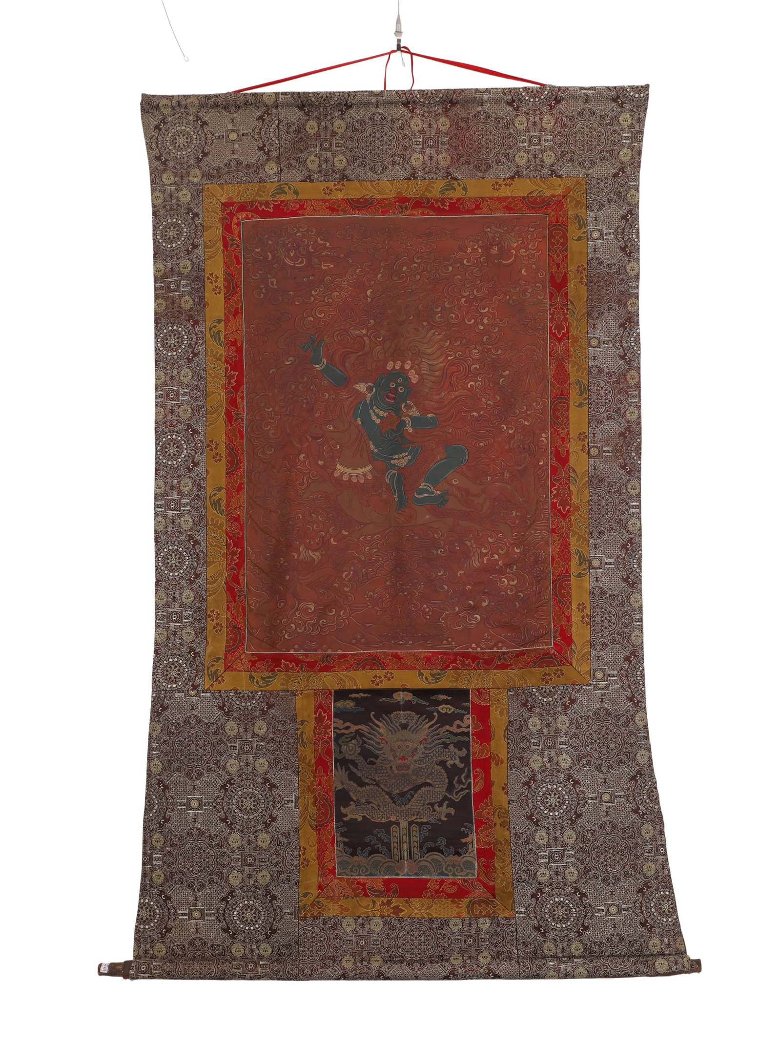 QING DYNASTY RED BACKGROUND VAJRA HAND BODHISATTVA THANGKA: H:73cm (28.74in) W:51cm (20.08in)The main deity is Vajrapani Bodhisattva, with dark blue wrathful appearance and vigorous dancing posture, surrounded by flame patterns. Painted in classic ancient red-